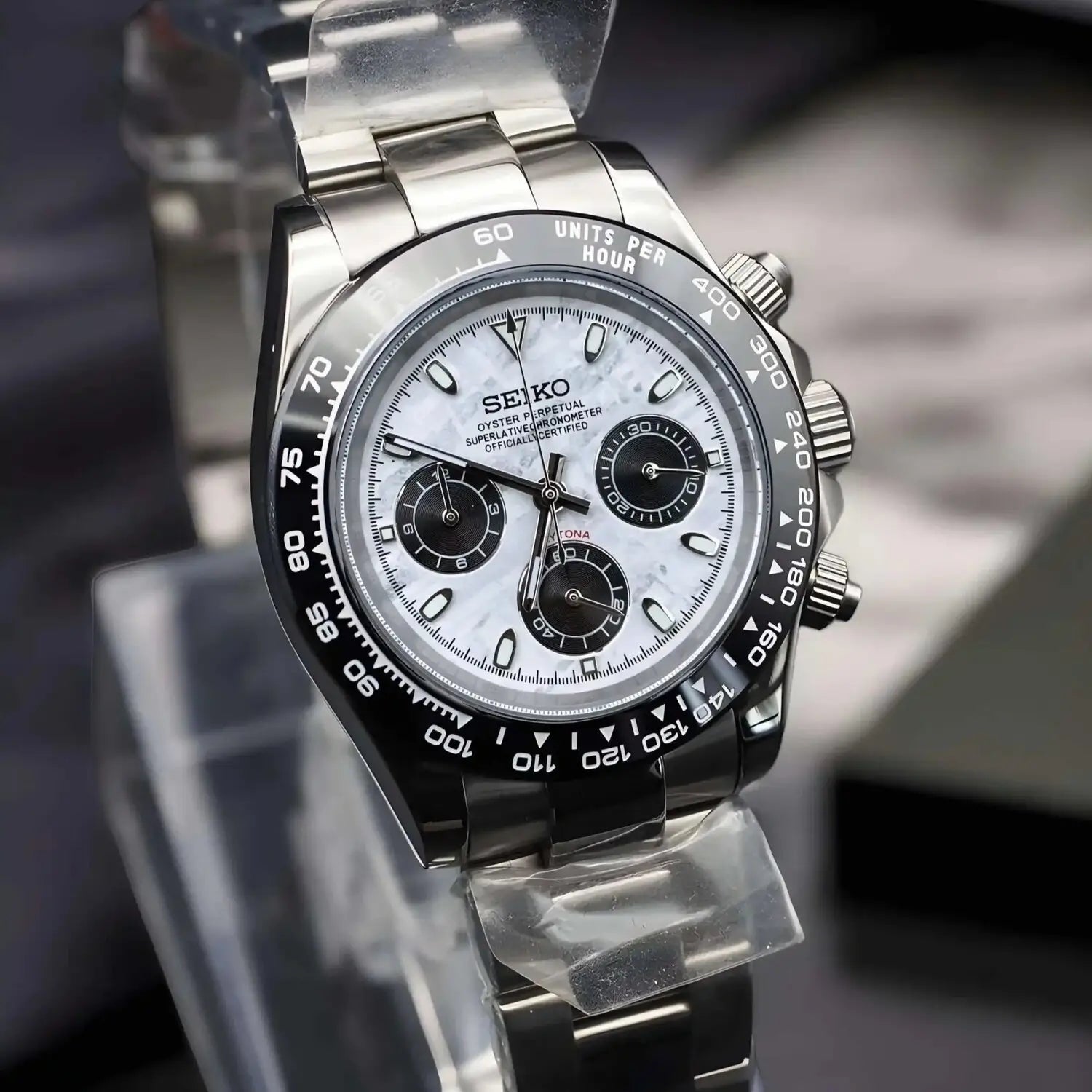 Seiko Mod Daytona Meteorite. Watch viewed from the left side with genuine meteorite dial, black bezel, and stainless steel bracelet. Luxurious Daytona inspired mod