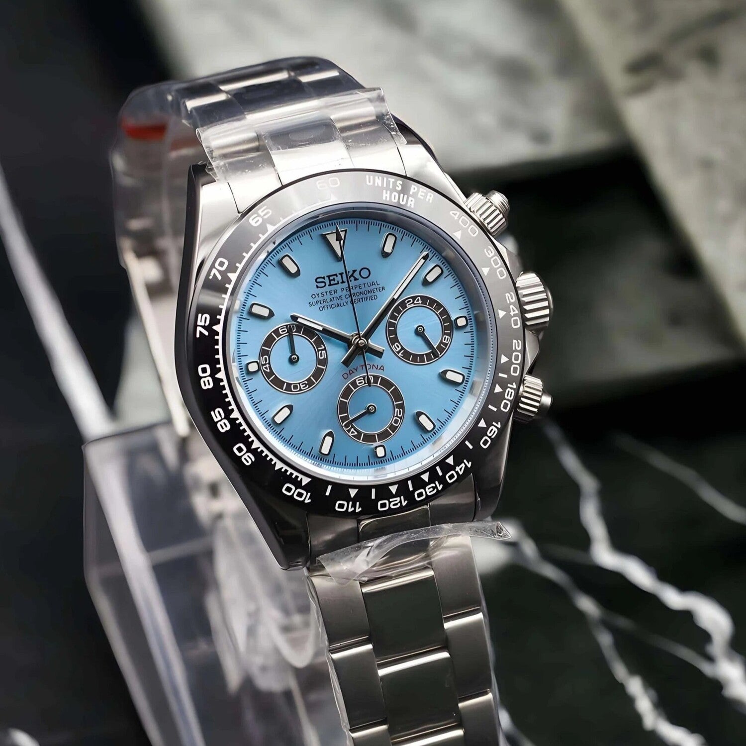 Angled view of the Seiko Mod Daytona with ice blue dial, three black ringed subdials, stainless steel case, black tachymeter bezel, and polished bracelet.