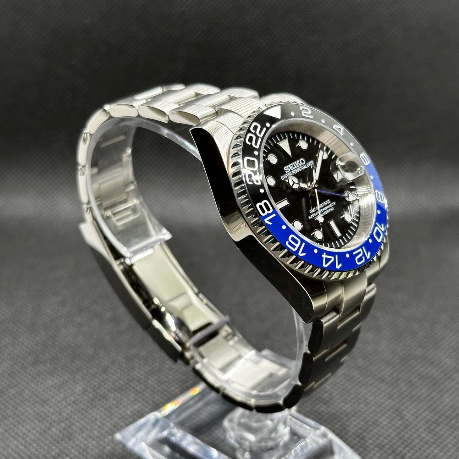 Left angled view Seiko Mod GMT Batman displaying black blue ceramic bezel and stainless bracelet