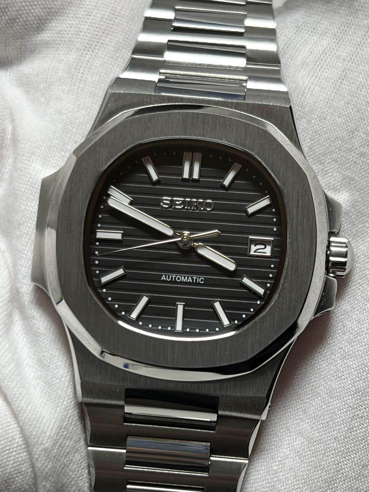 Full frontal shot of Seiko mod Nautilus black showcasing bold bezel and clean design