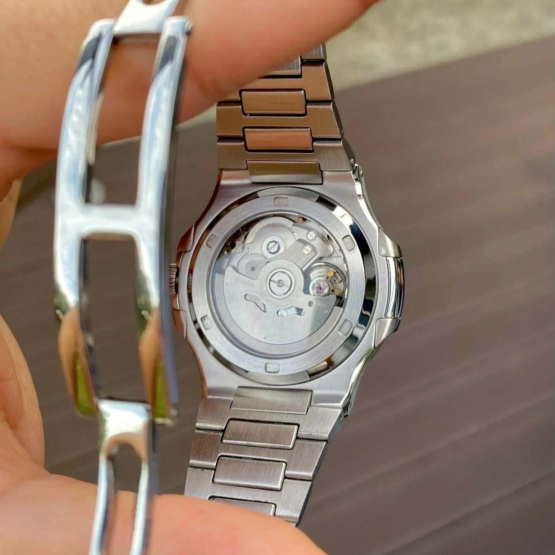 Transparent case back of Seiko mod Nautilus black open heart showing NH35 rotor and gears