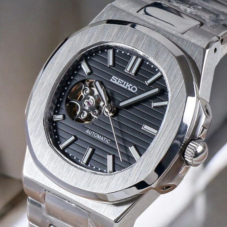 Right angled close up of Seiko mod Nautilus black open heart highlighting exposed balance wheel