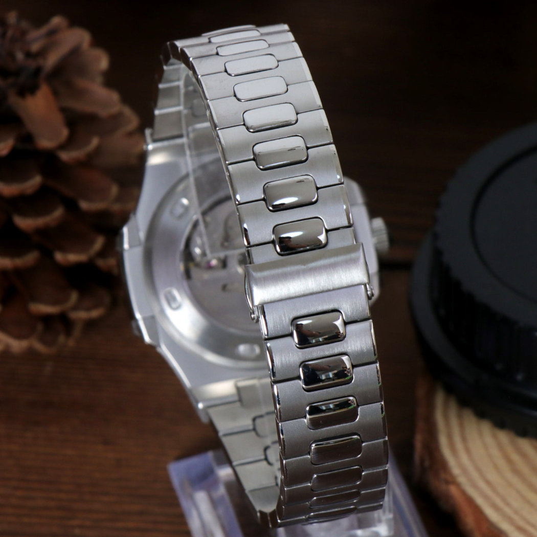 Stainless bracelet of Seiko mod Nautilus brown edition on wood background beside pinecone