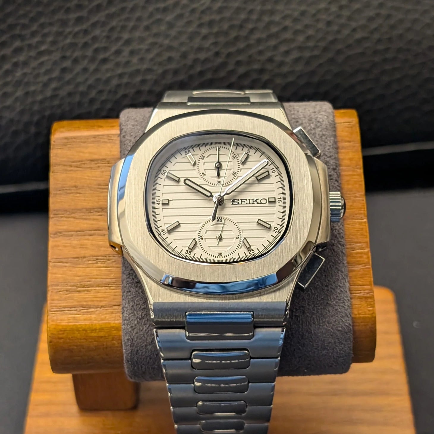 Seiko mod Nautilus chronograph white displayed on wooden stand showing integrated bracelet