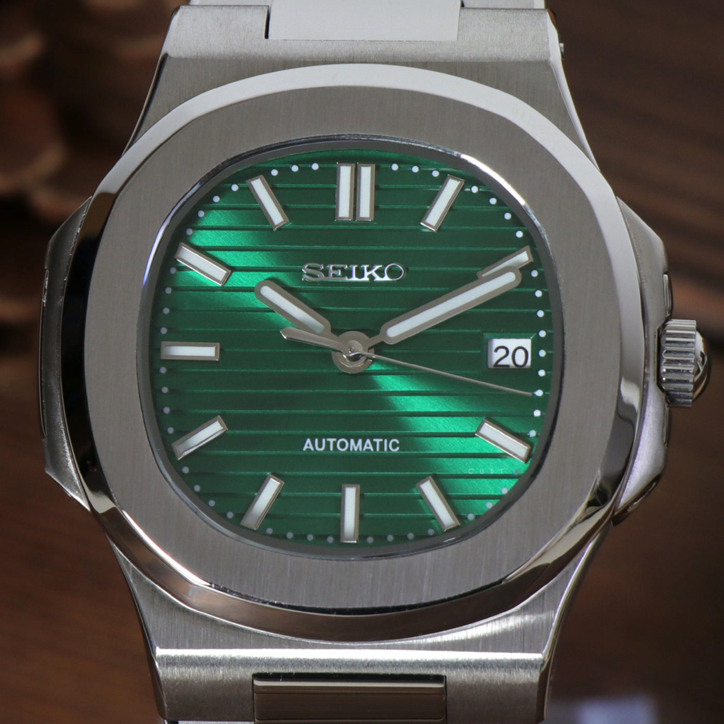 Close up of Seiko mod Nautilus green metallic dial with horizontal texture and luminous hour markers