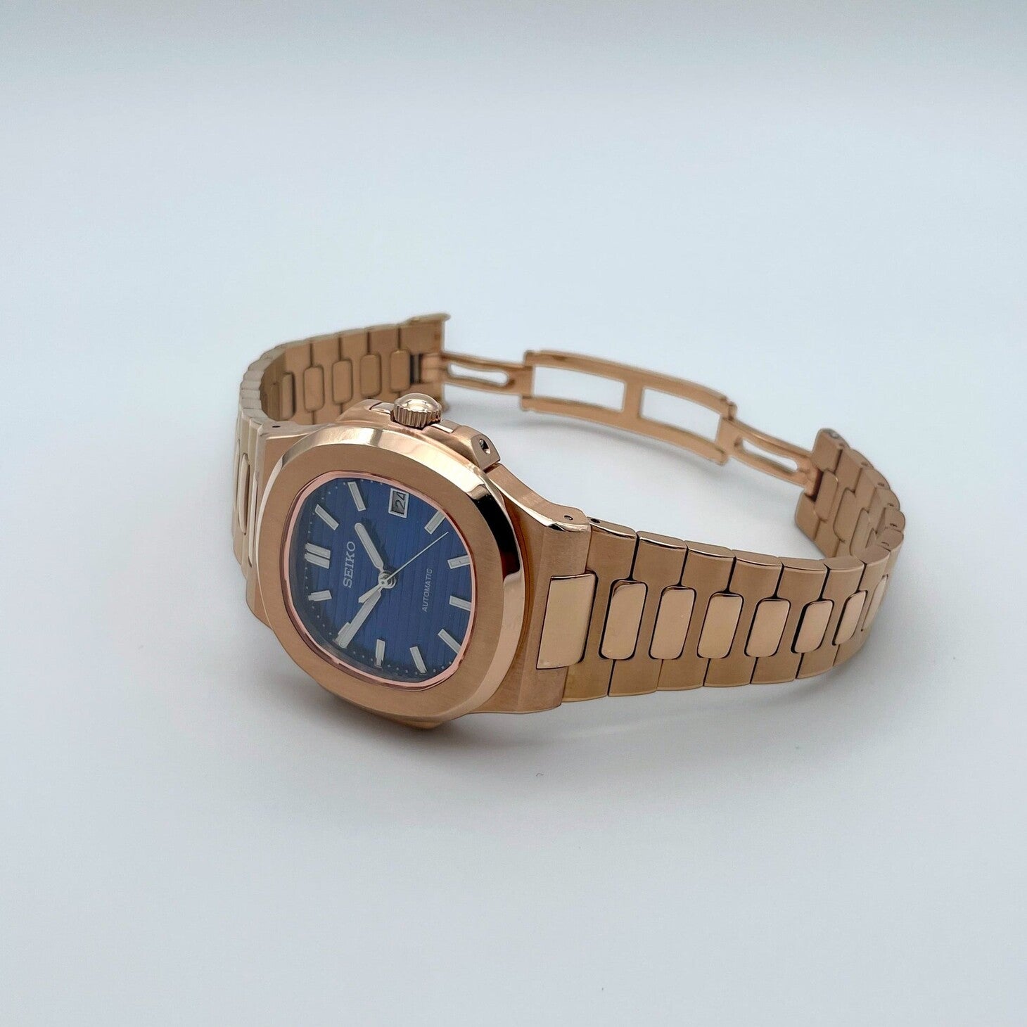 Horizontal view of Seiko mod Nautilus rose gold royal blue edition displaying integrated bracelet lines