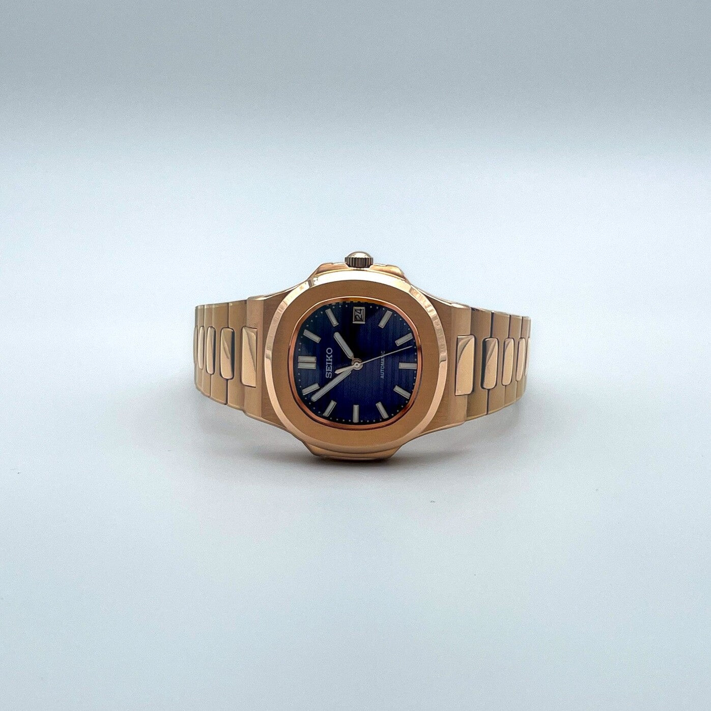 Lying view of Seiko mod Nautilus rose gold royal blue edition showing overall symmetry and sleek proportions