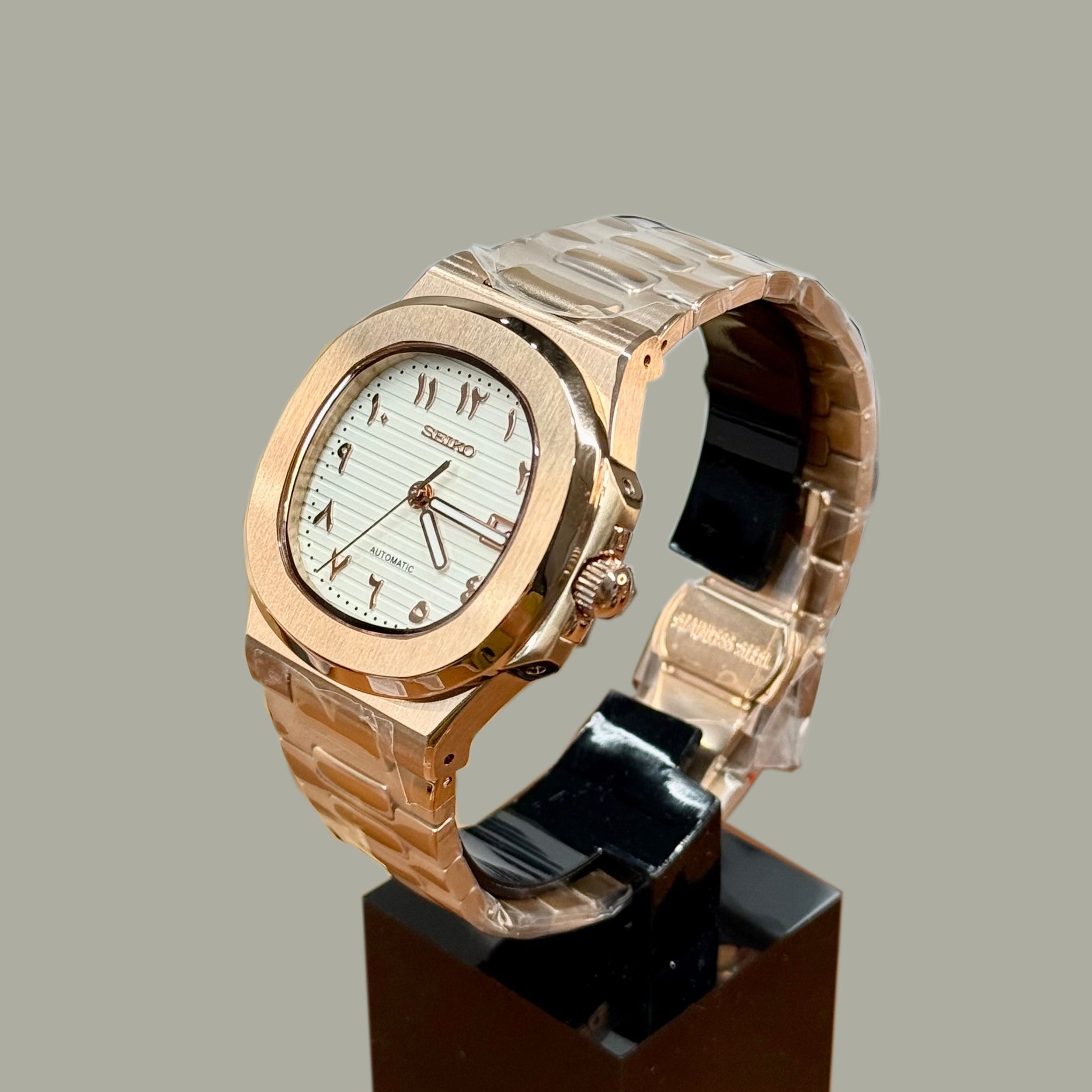 Right angled view of Seiko mod Nautilus rose gold white Arabic edition highlighting polished bezel and integrated bracelet