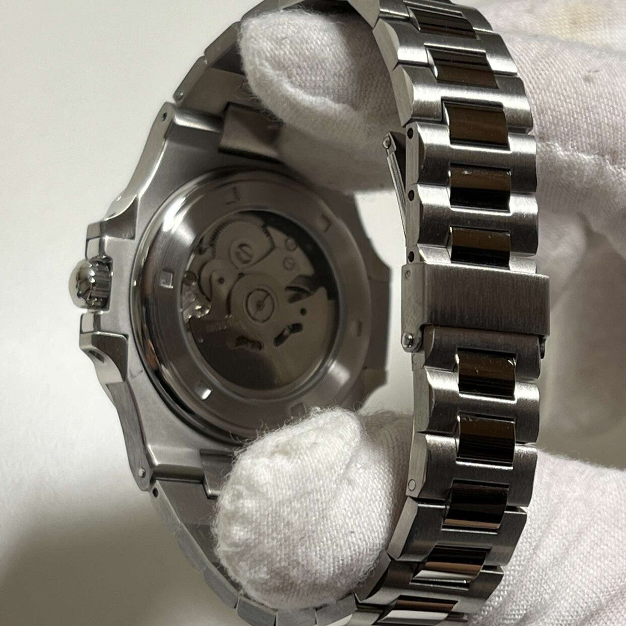 Transparent case back of Seiko mod Nautilus royal blue edition revealing movement details and brushed steel finish