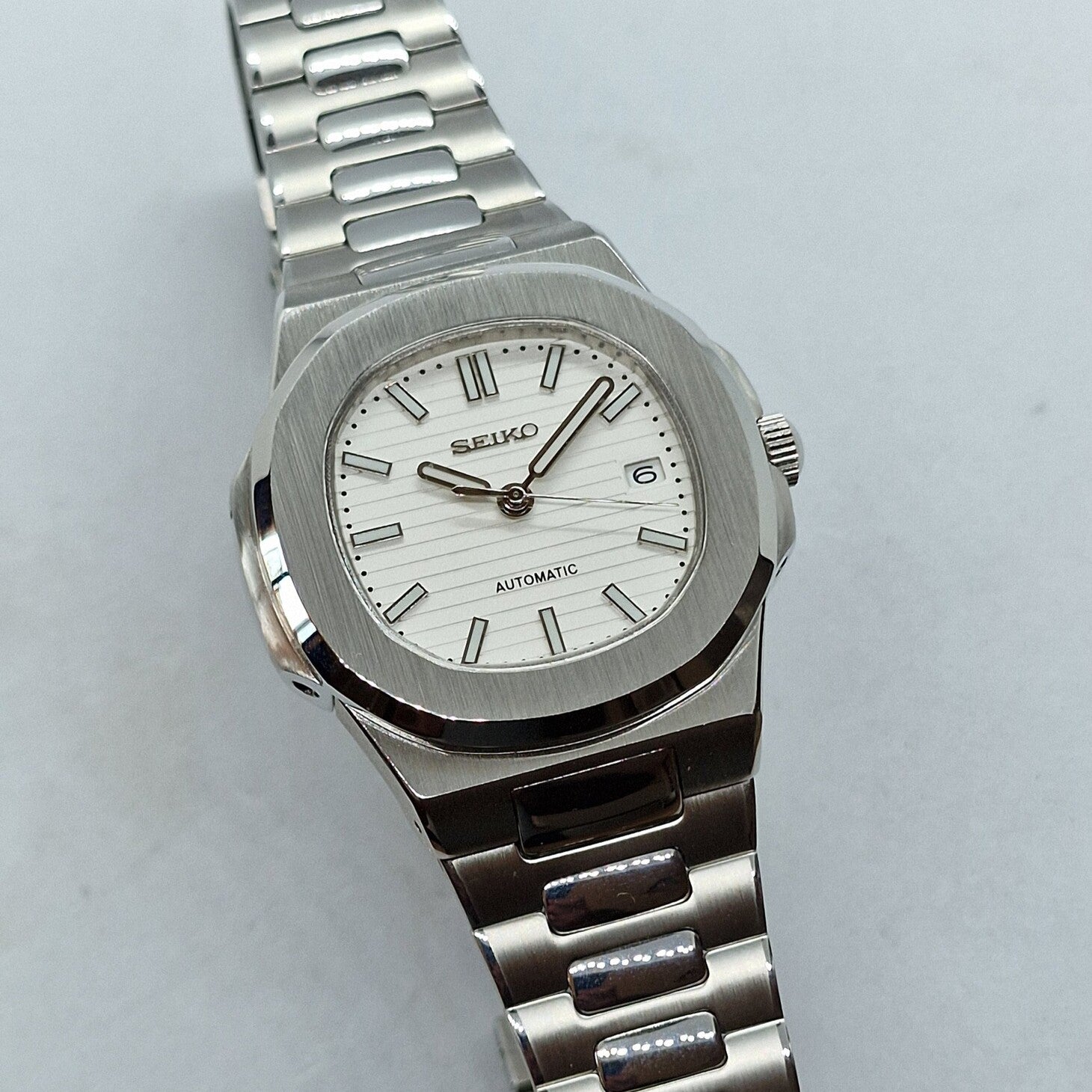 Tilted view Seiko Mod Nautilus White showing dial depth and bracelet reflection