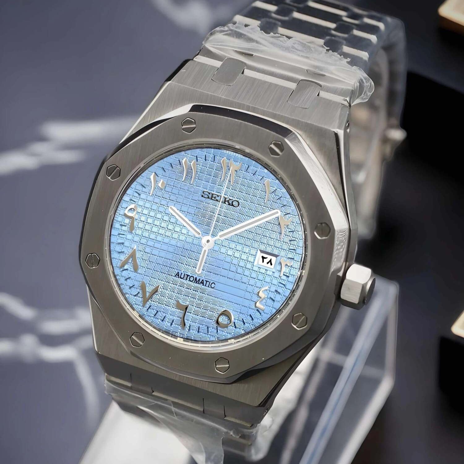 Right angle view of a Seiko Mod Royal Oak with ice blue Arabic dial, silver hands and indices, brushed stainless steel case, and integrated steel bracelet.