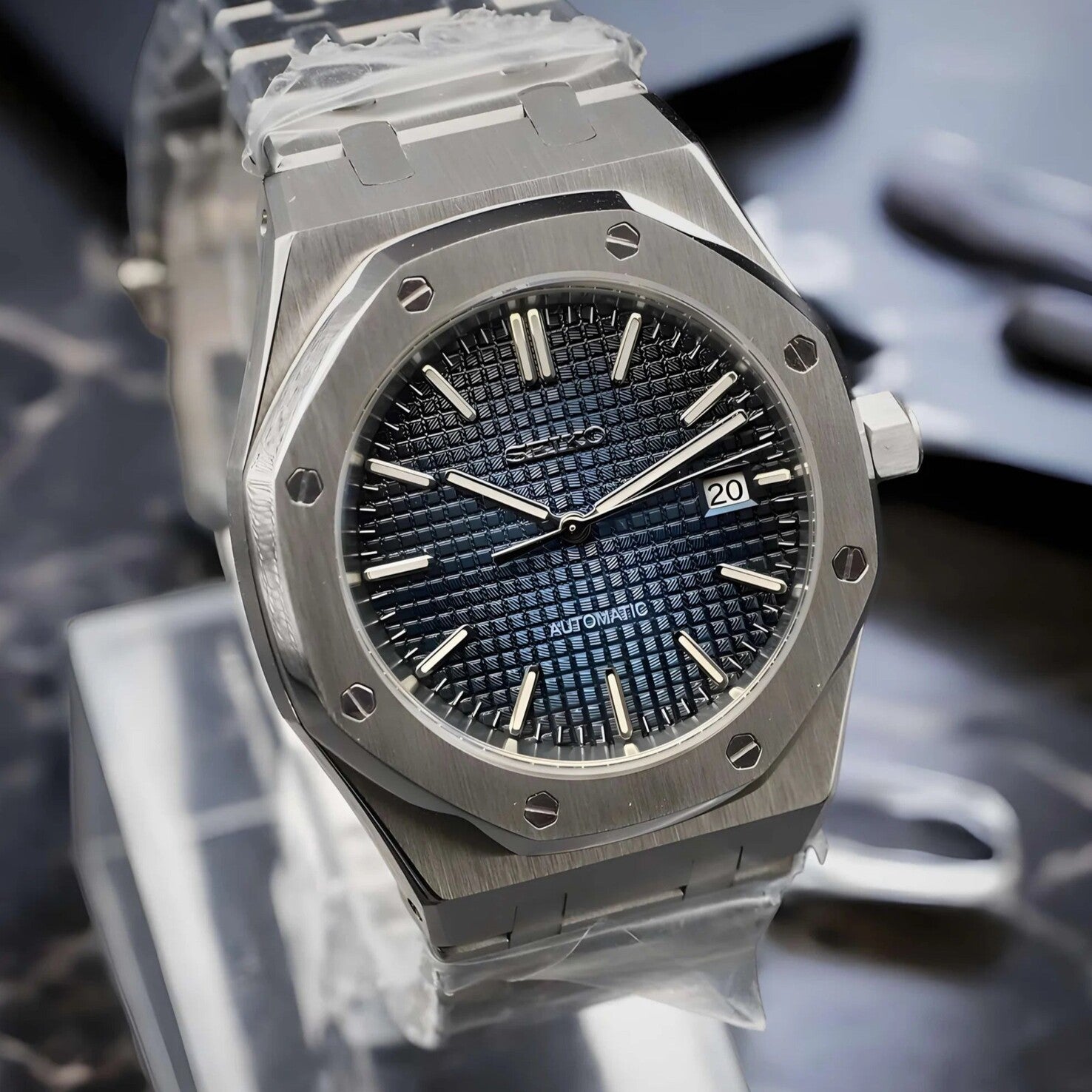 Angled view of the Seiko Mod Royal Oak automatic watch with navy blue textured dial, brushed stainless steel case, and date window at three o’clock