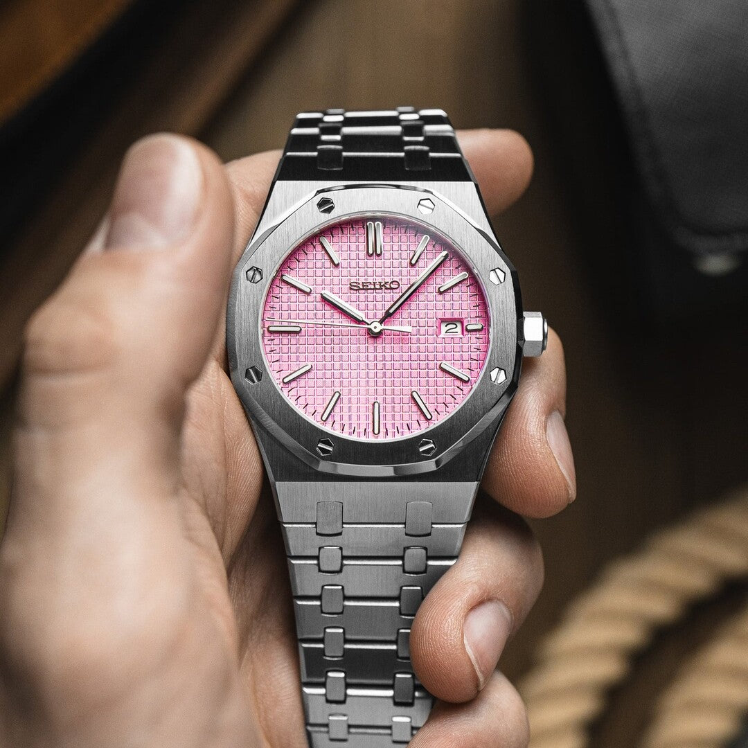 Front view of Seiko Mod Royal Oak watch featuring a vivid pink textured dial with silver baton indices, housed in a brushed stainless steel octagonal case, paired with an integrated steel bracelet