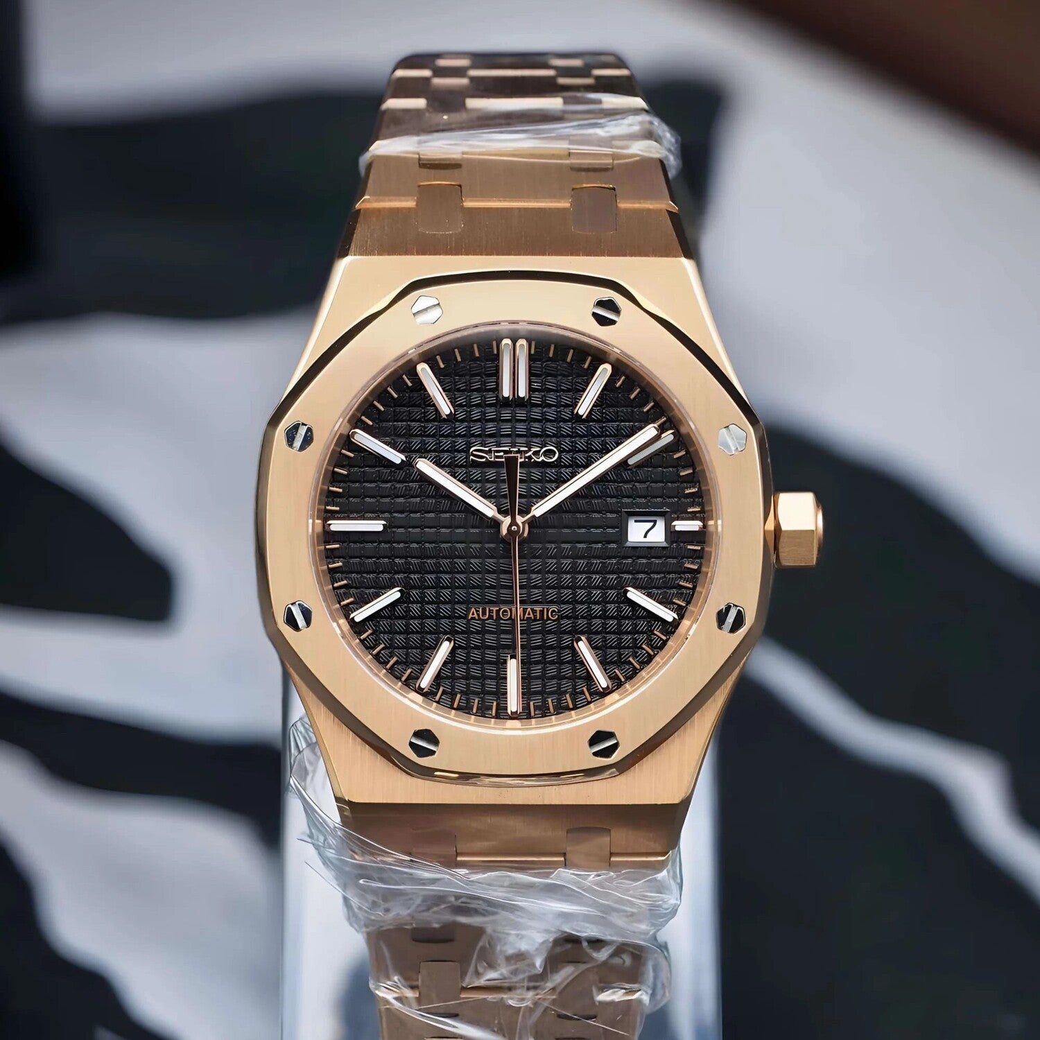 Front view of Seiko Mod Royal Oak in rose gold, featuring a brushed octagonal bezel, black textured dial with date window, and luminous hands, showcasing the refined contrast of case and dial.