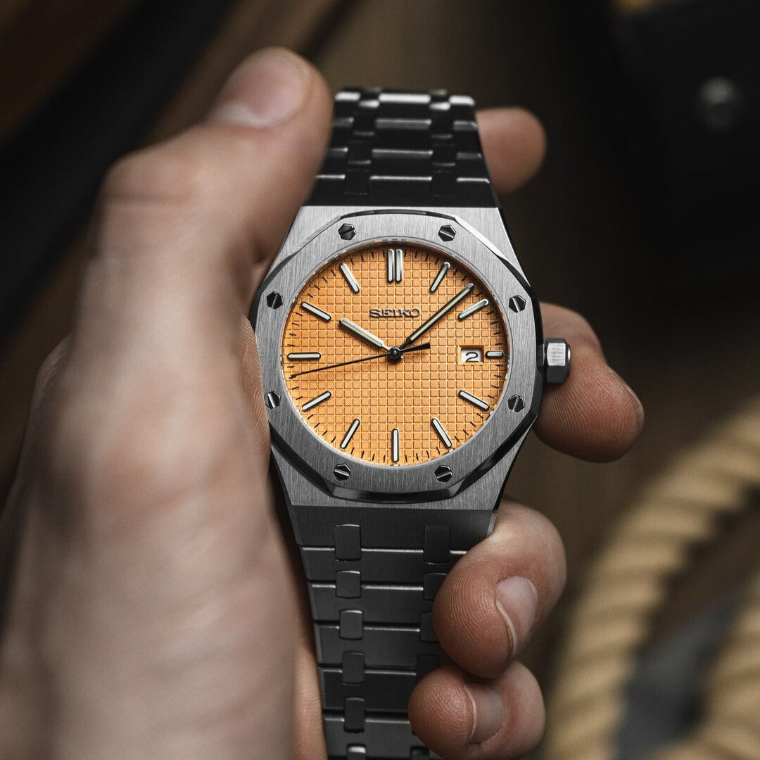 Top view of the Seiko Mod Royal Oak showing a salmon patterned dial with silver hour markers, octagonal brushed steel bezel secured by visible screws, and integrated stainless steel bracelet.