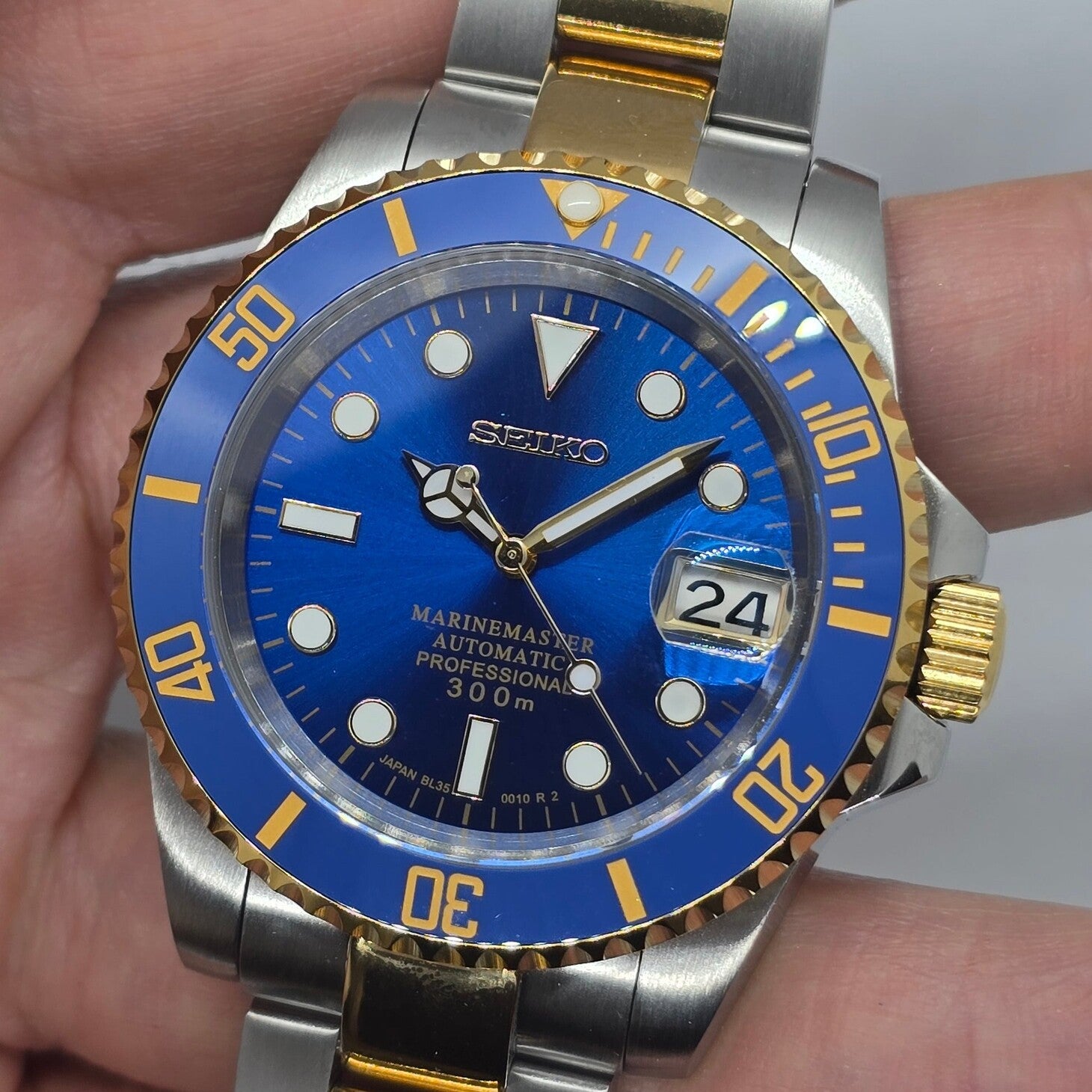 Front view Seiko Mod Submariner blue dial centered composition with gold accents