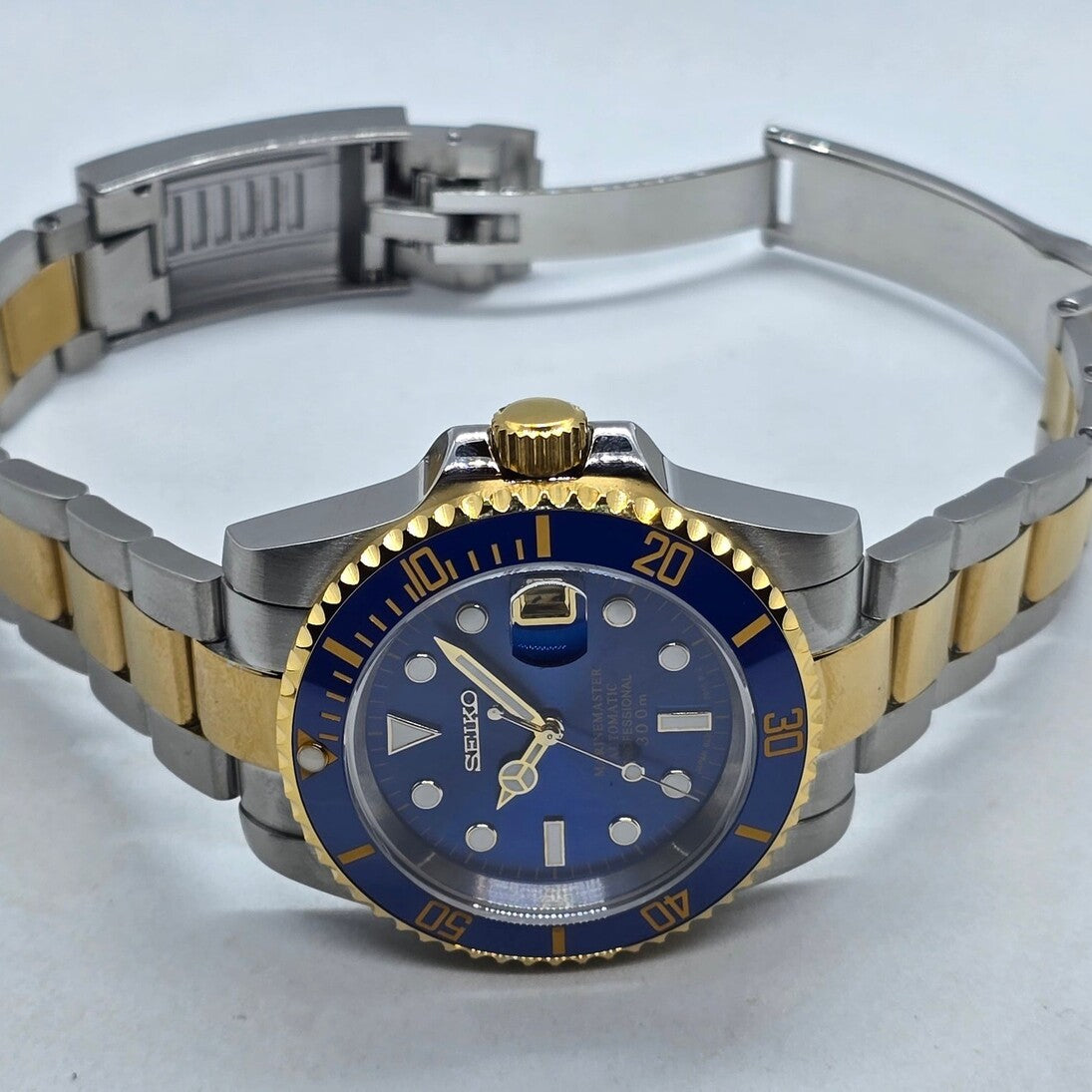 Horizontal view Seiko Mod Submariner blue two tone bracelet open clasp side case angle