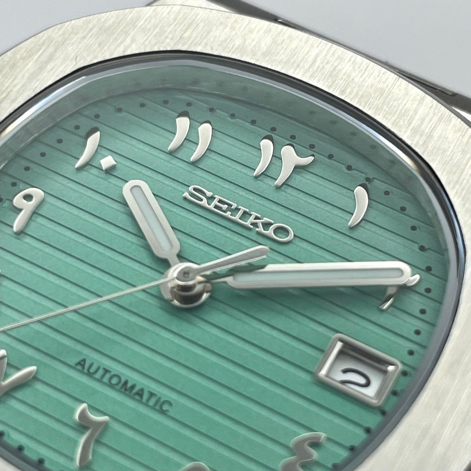 Close up Seiko Mod Nautilus Tiffany Arabic showing mint green dial and Arabic numerals near logo