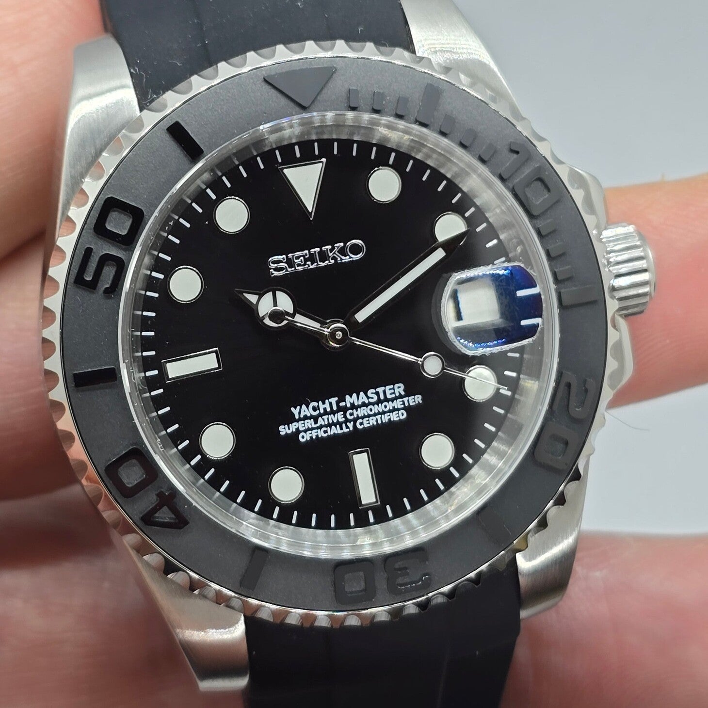 Dial close view Seiko Mod Yachtmaster black face with raised markers and red text detail