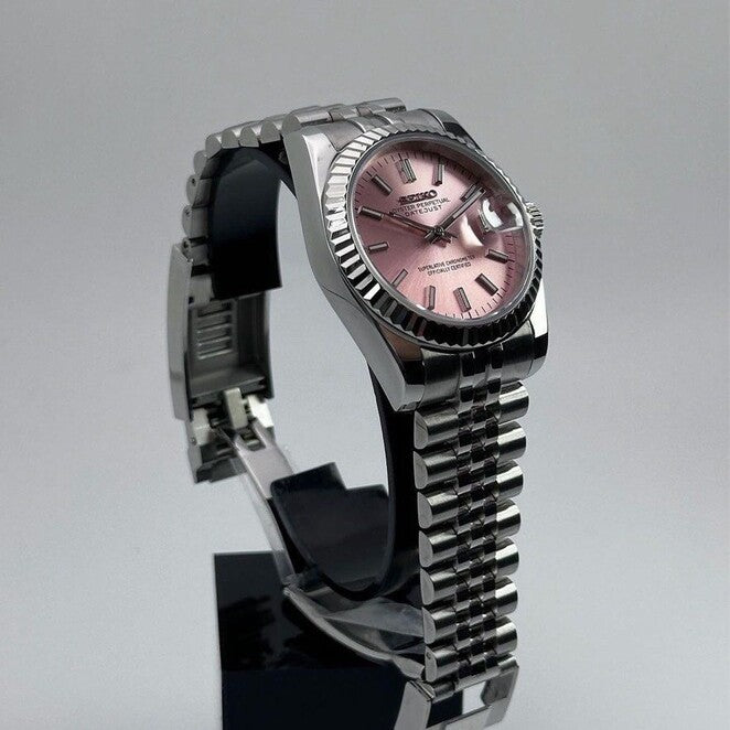 Seiko Mod Datejust Pink Schrägansicht mit rosafarbenem Sunburst-Zifferblatt, Fluted Bezel, Edelstahlgehäuse und poliertem Finish