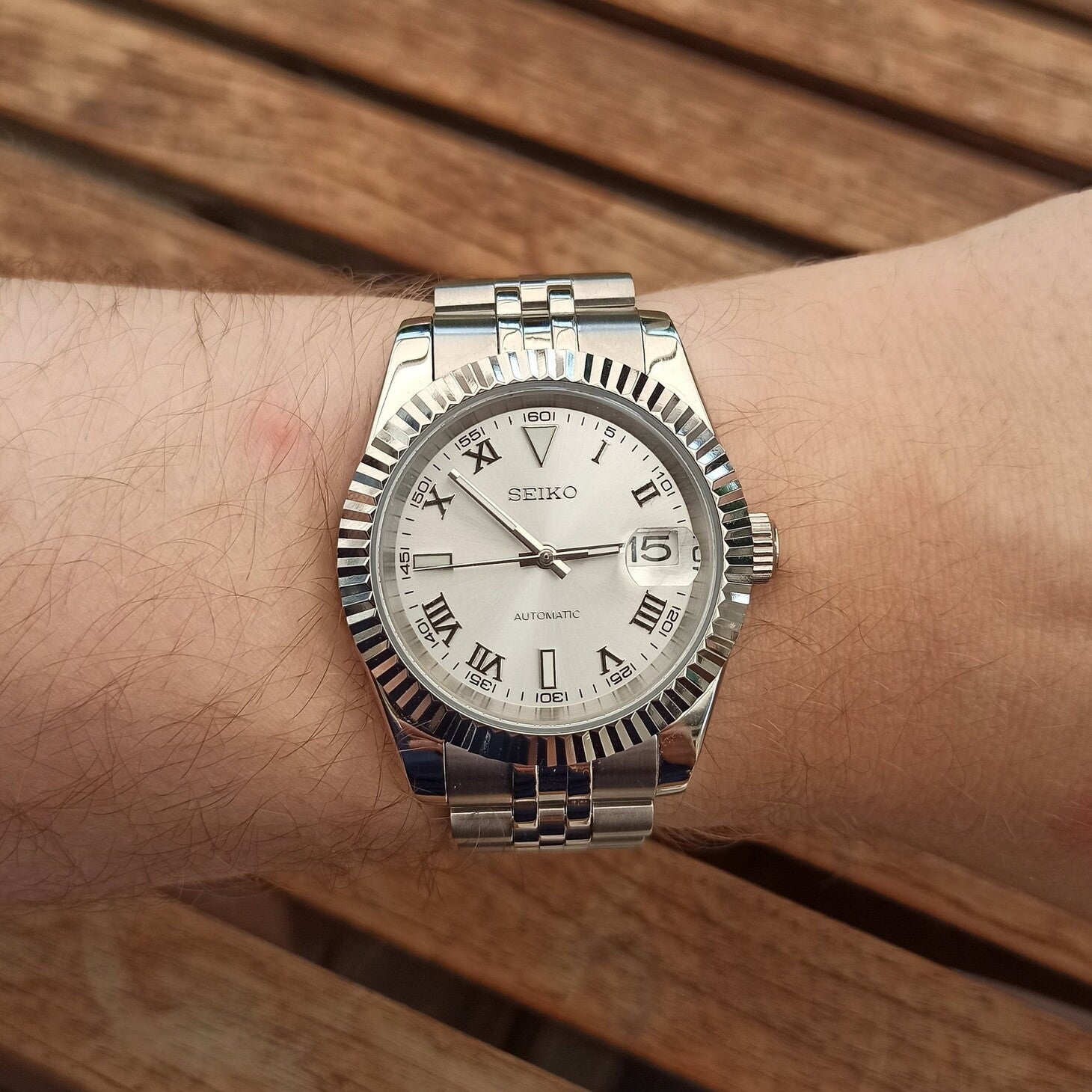 Datejust Silver Roman Handgelenk Aufnahme mit silbernem Zifferblatt, römischen Ziffern, Jubilee Armband und Tageslich