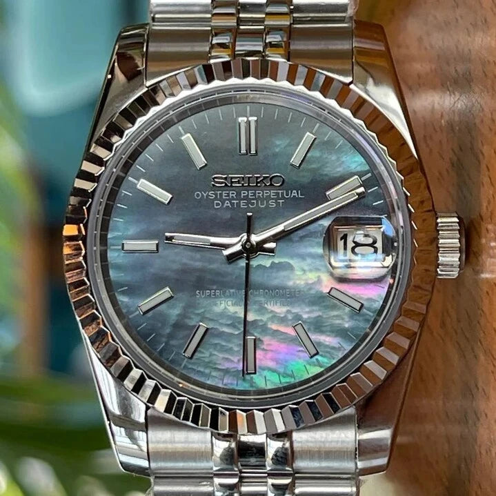 Nahaufnahme der Seiko Mod Datejust Cosmos mit irisierendem Perlmutt-Zifferblatt in Blau-Violett, Datumsanzeige bei 3 Uhr mit Zyklop-Lupe, Edelstahlgehäuse und Jubilee-Armband