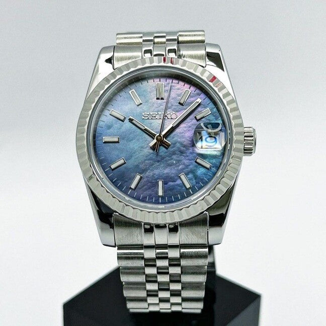 Seiko Mod Datejust Cosmos Luxusuhr mit schimmerndem Perlmutt-Zifferblatt in Blau-Violett, Edelstahlgehäuse 40mm, gerillter Lünette und Jubilee-Armband auf Uhrenständer