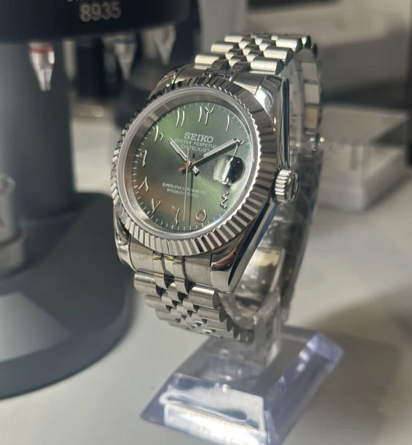 Seiko Mod Datejust Mint Green Arabic Seitenansicht mit Mint Green Zifferblatt, arabischen Ziffern, Edelstahlgehäuse 40mm und gerillter Lünette auf Uhrenständer