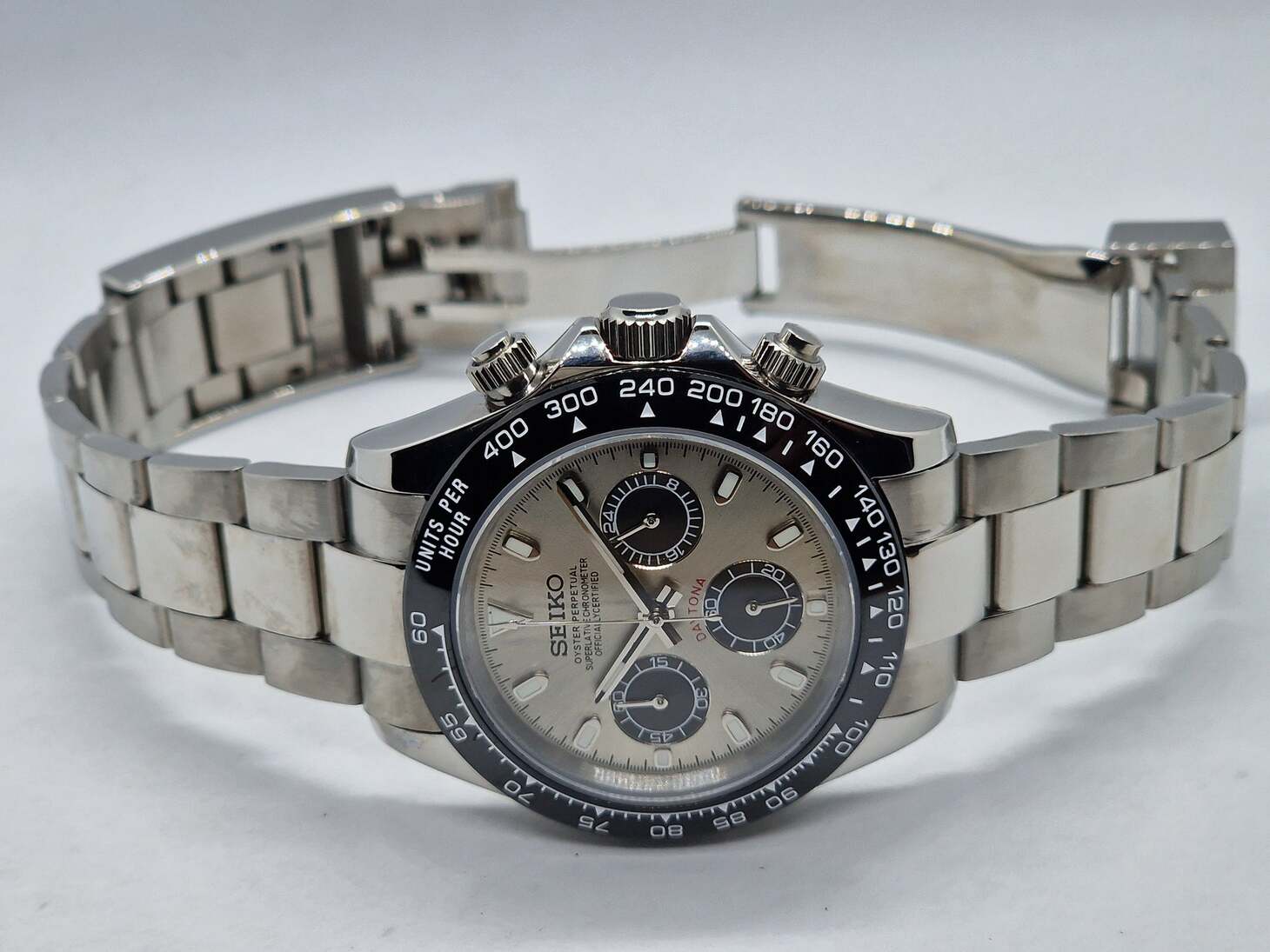 Seiko Mod Daytona Champagne Schrägansicht mit champagnerfarbenem Zifferblatt, schwarzen Subdials, Tachymeter-Lünette und Edelstahlarmband