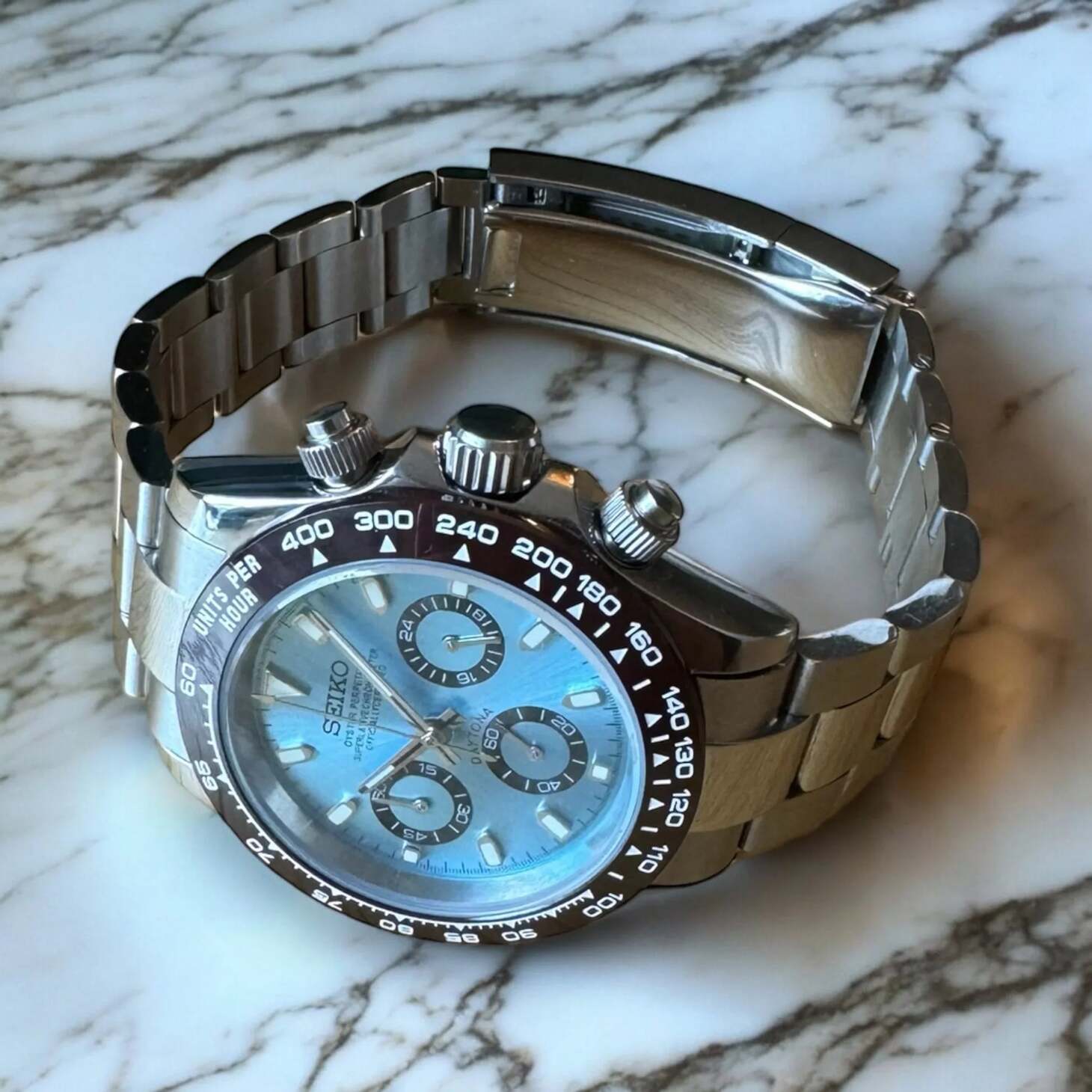 Seiko Mod Daytona Platinum Detailansicht mit eisblauem Zifferblatt, polierter Krone und Tachymeter-Lünette
