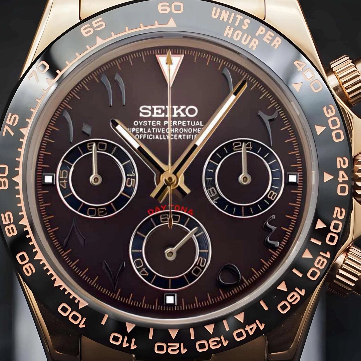 Nahaufnahme der Seiko Mod Daytona Rose Gold Brown Arabic mit braunem Zifferblatt, arabischen Ziffern, Roségold-Indizes, drei schwarzen Totalisatoren, VK63 Chronograph-Funktion und schwarzer Keramik-Lünette