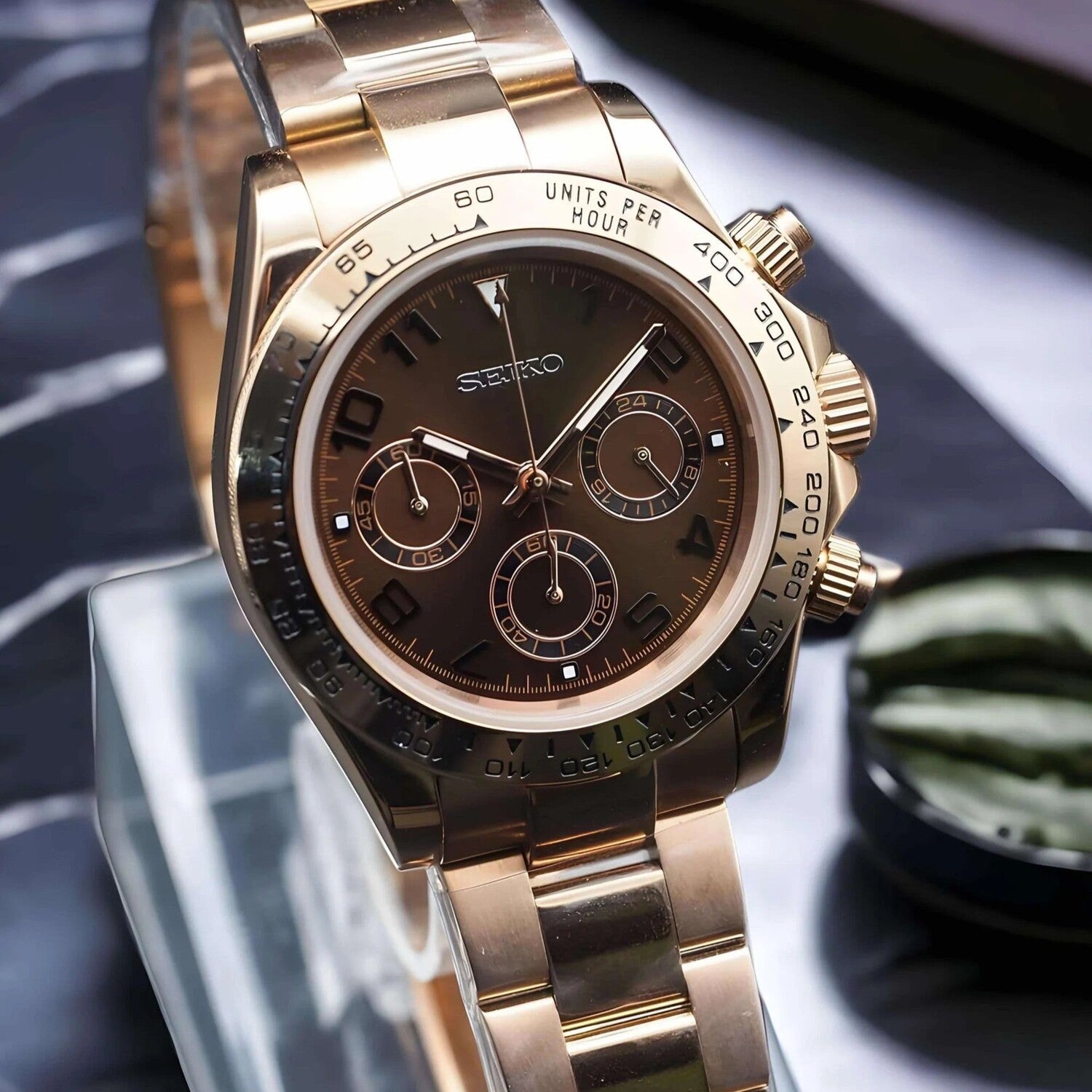 Seiko Mod Daytona Rose Gold Chocolate Schrägansicht mit Roségold-Edelstahlgehäuse 40mm, Chocolate-Zifferblatt, schwarzer Keramik-Tachymeter-Lünette, VK63 Uhrwerk und poliertem Oyster-Armband