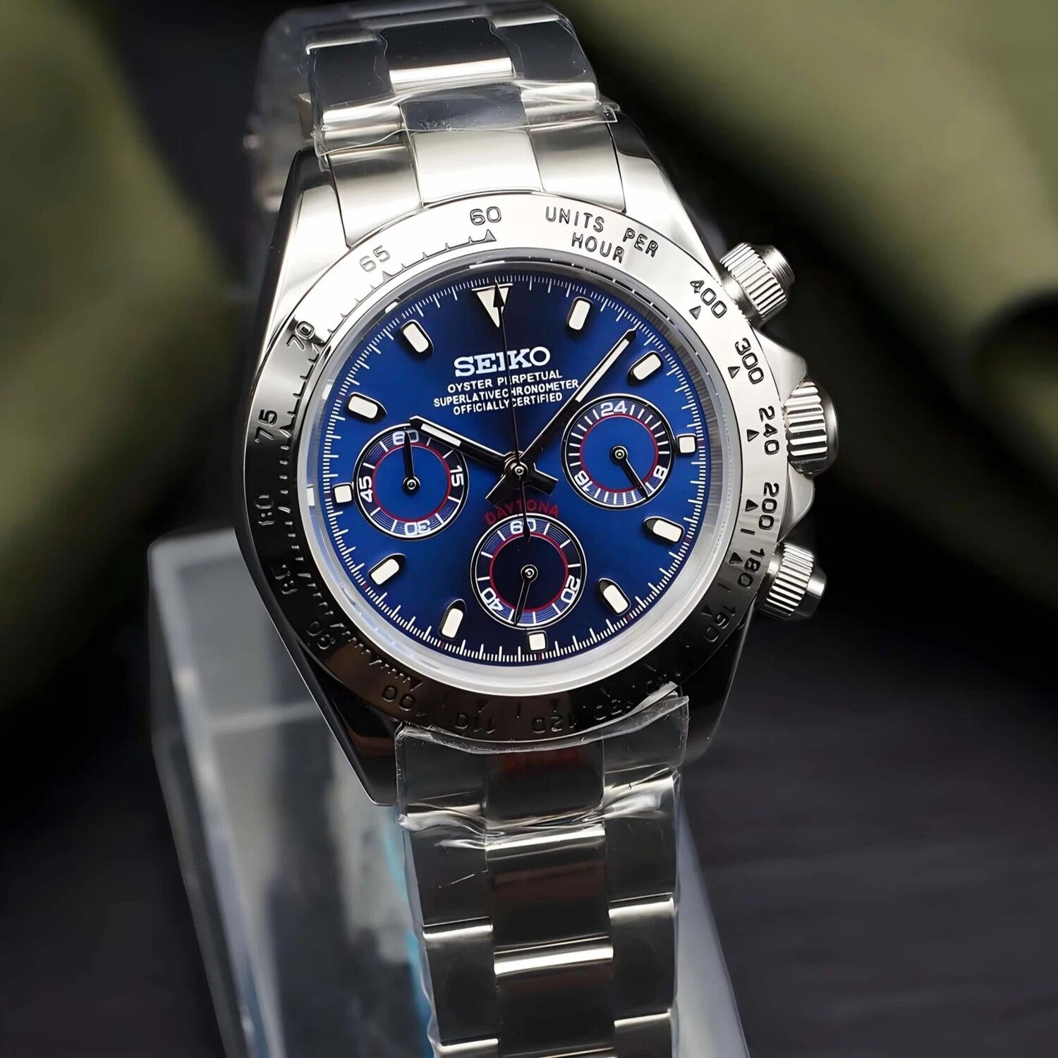 Seiko Mod Daytona Royal Blue Metallic Schrägansicht mit metallischem Royal Blue Zifferblatt, silbernen Totalisatoren mit roten Akzenten, Edelstahl-Tachymeter-Lünette, poliertem Oyster-Armband und VK63 Uhrwerk