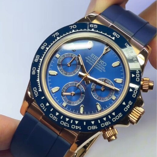 Seiko Mod Daytona Royal Blue Schrägansicht mit Sunburst-Zifferblatt, roségoldenen Chronograph-Drückern und marineblauen Armband