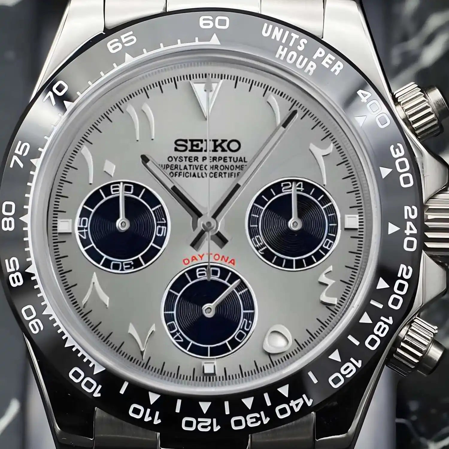 Nahaufnahme der Seiko Mod Daytona Silver Arabic mit silbernem Zifferblatt, arabischen Ziffern, drei schwarzen Totalisatoren, VK63 Chronograph-Funktion und schwarzer Keramik-Tachymeter-Lünette