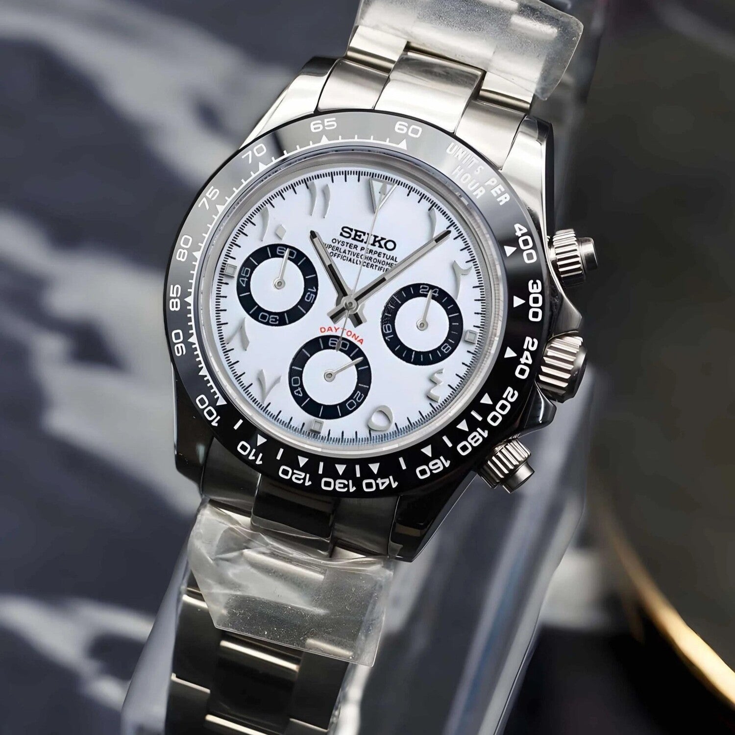 Seiko Mod Daytona White Arabic Seitenansicht mit weißem Zifferblatt, schwarzer Keramik-Lünette, Oyster-Edelstahlarmband, Schraubkrone, Chronograph-Drückern und VK63 Uhrwerk