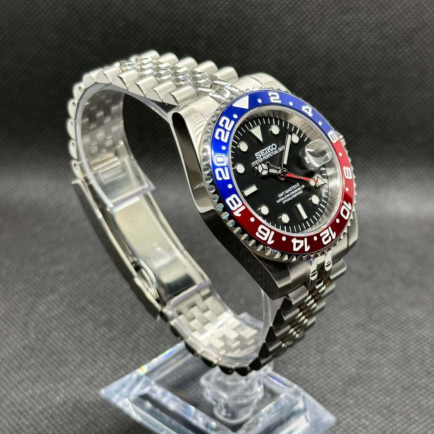 Seiko Mod GMT Pepsi Schrägansicht, Pepsi Lünette Farbsplit blau-rot, poliertes Edelstahlgehäuse, Jubilee Armband, GMT
