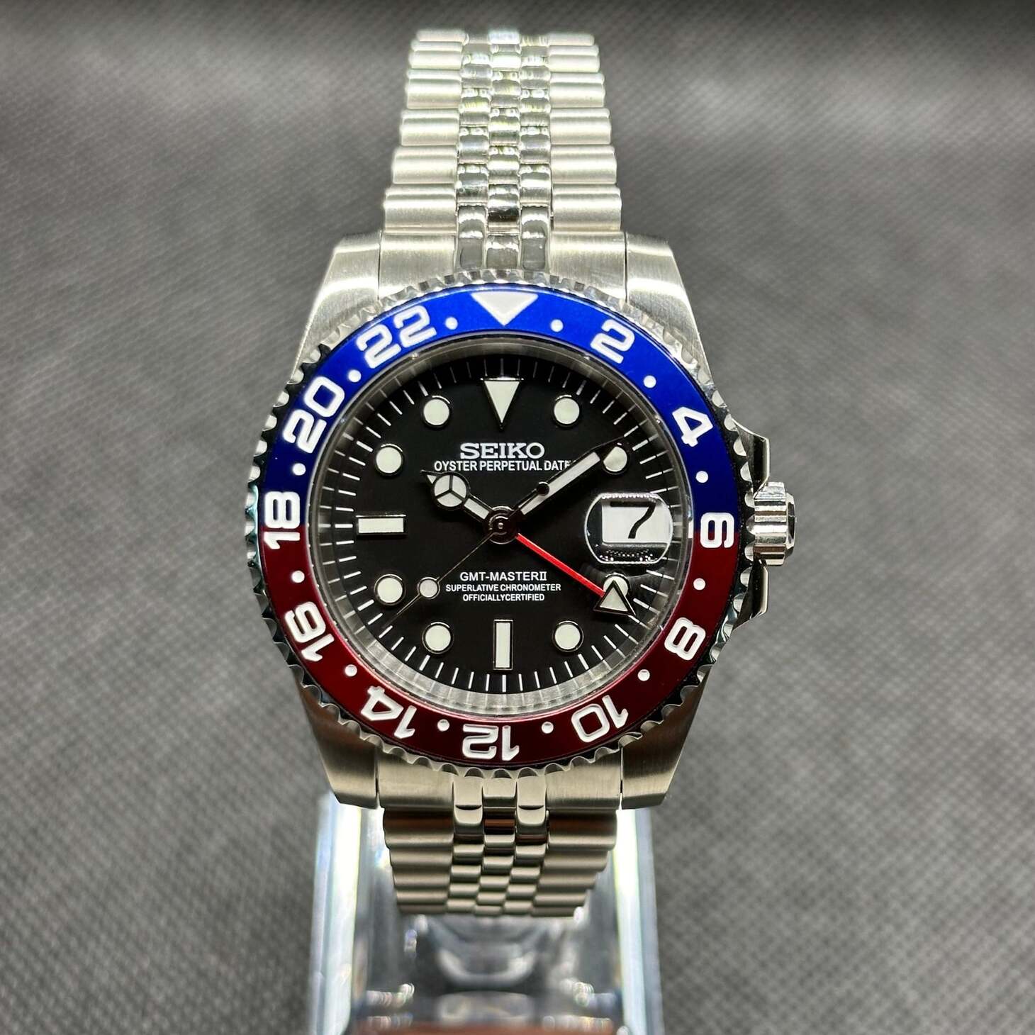 Seiko Mod GMT Pepsi Frontansicht, schwarzes Zifferblatt, roter GMT Zeiger, Leuchtindizes, Pepsi Lünette, Dual-Time-Funktion