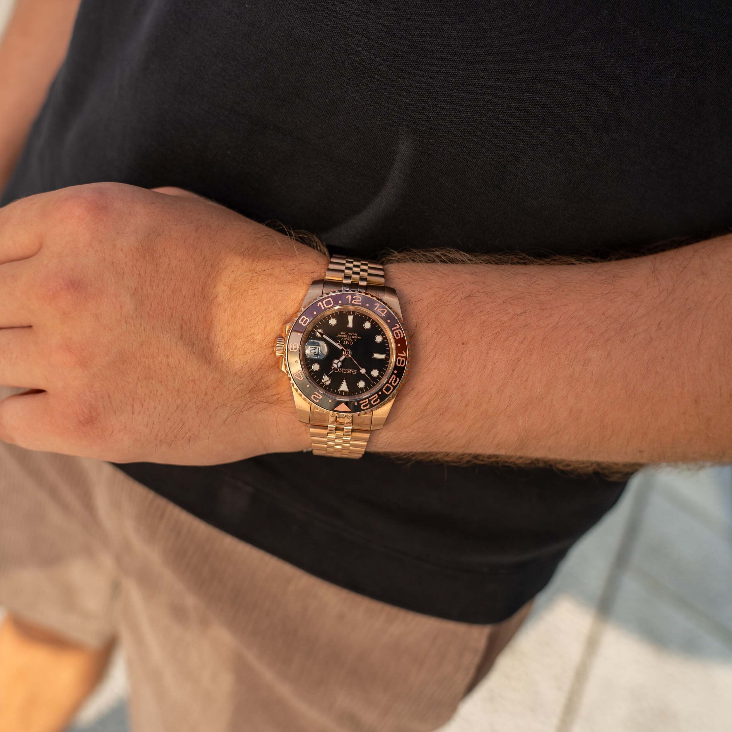 Seiko Mod GMT Rootbeer Rose Gold Handgelenk Aufnahme im Sonnenlicht fängt Rootbeer Lünetten Farbverlauf, Jubilee Armband Glanz und Roségold Wärme perfekt ein