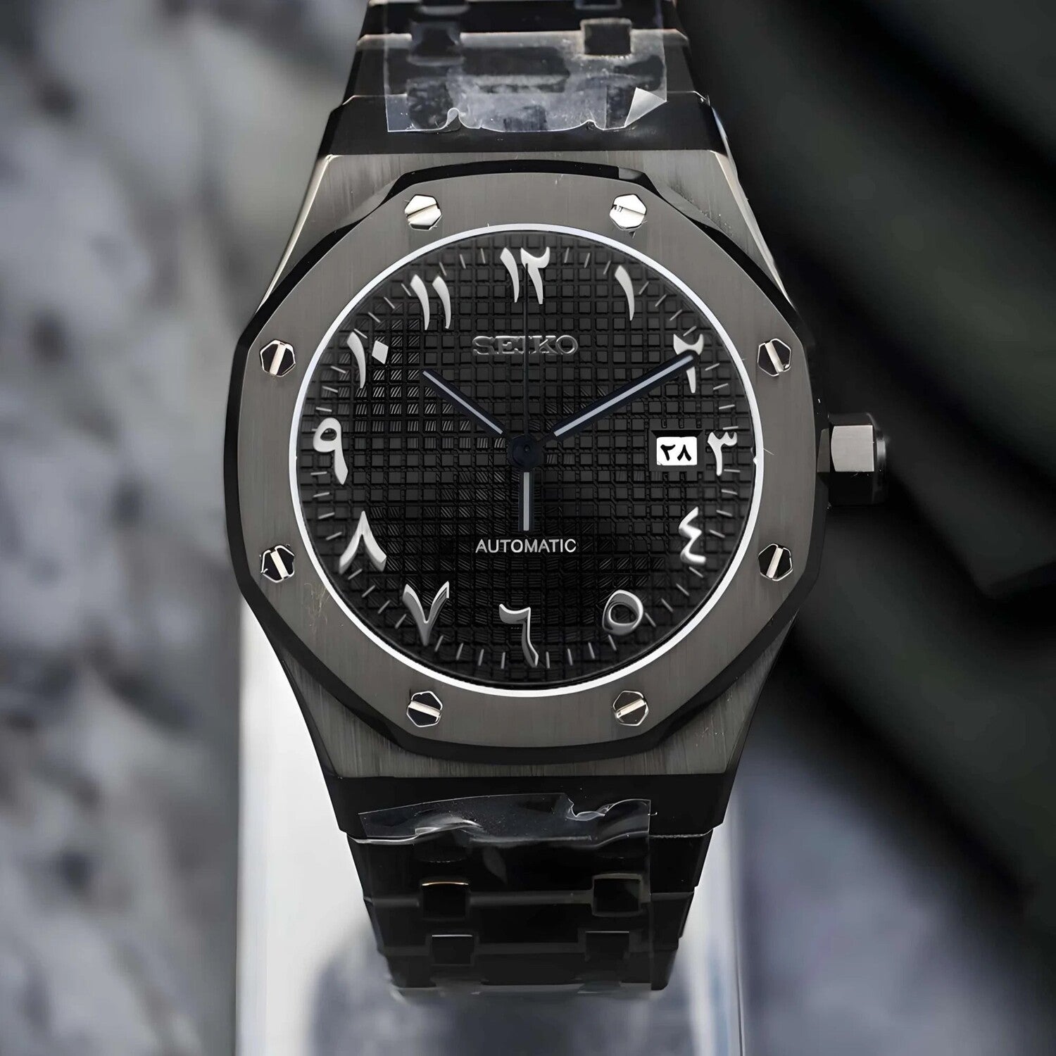 Frontansicht der Seiko Mod Royal Oak All Black Arabic Luxusuhr mit arabischen Ziffern, strukturiertem Zifferblatt und integriertem Armband