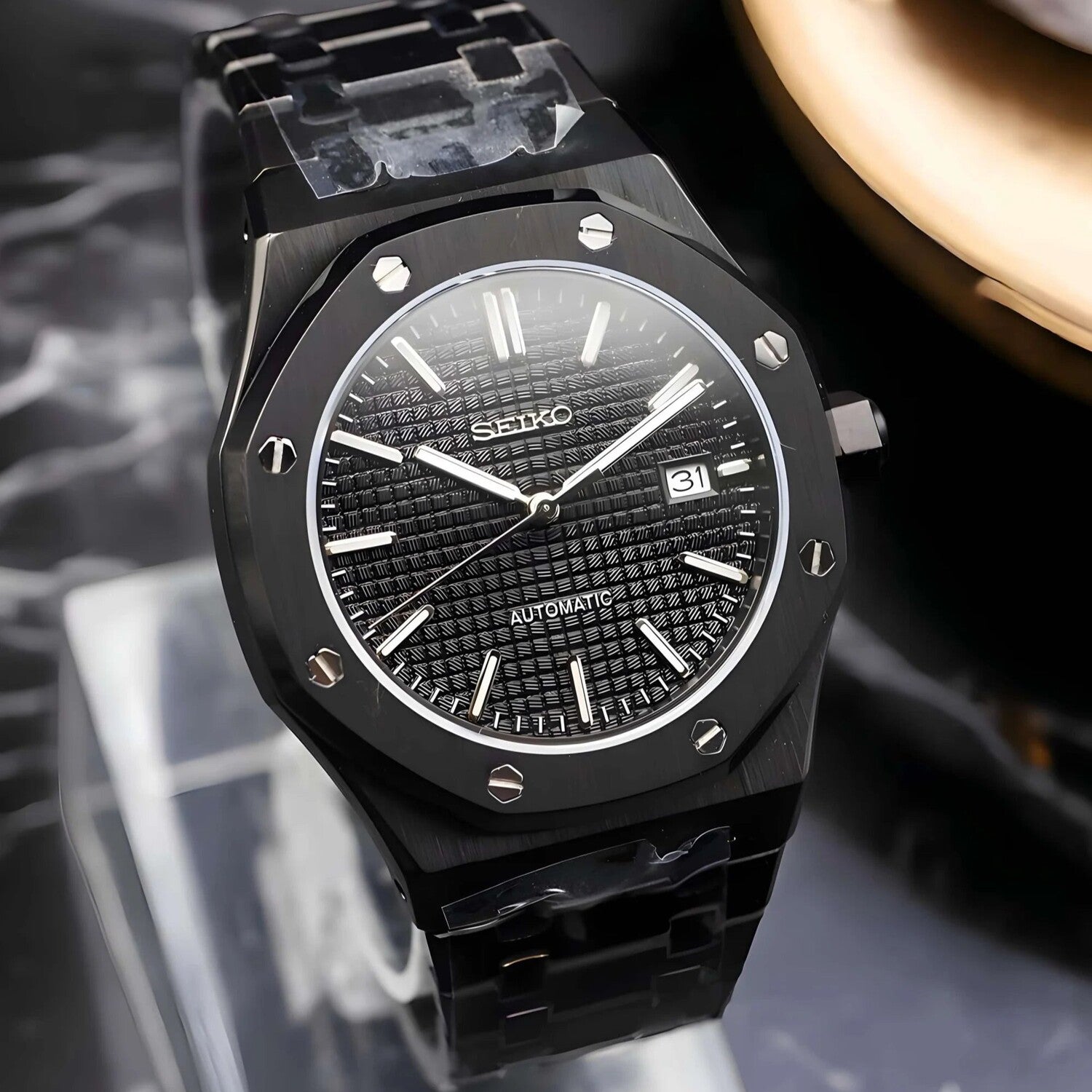 Seitenansicht der Seiko Mod Royal Oak All Black mit gebürstetem achteckigem Edelstahlgehäuse und integriertem Armband-Design
