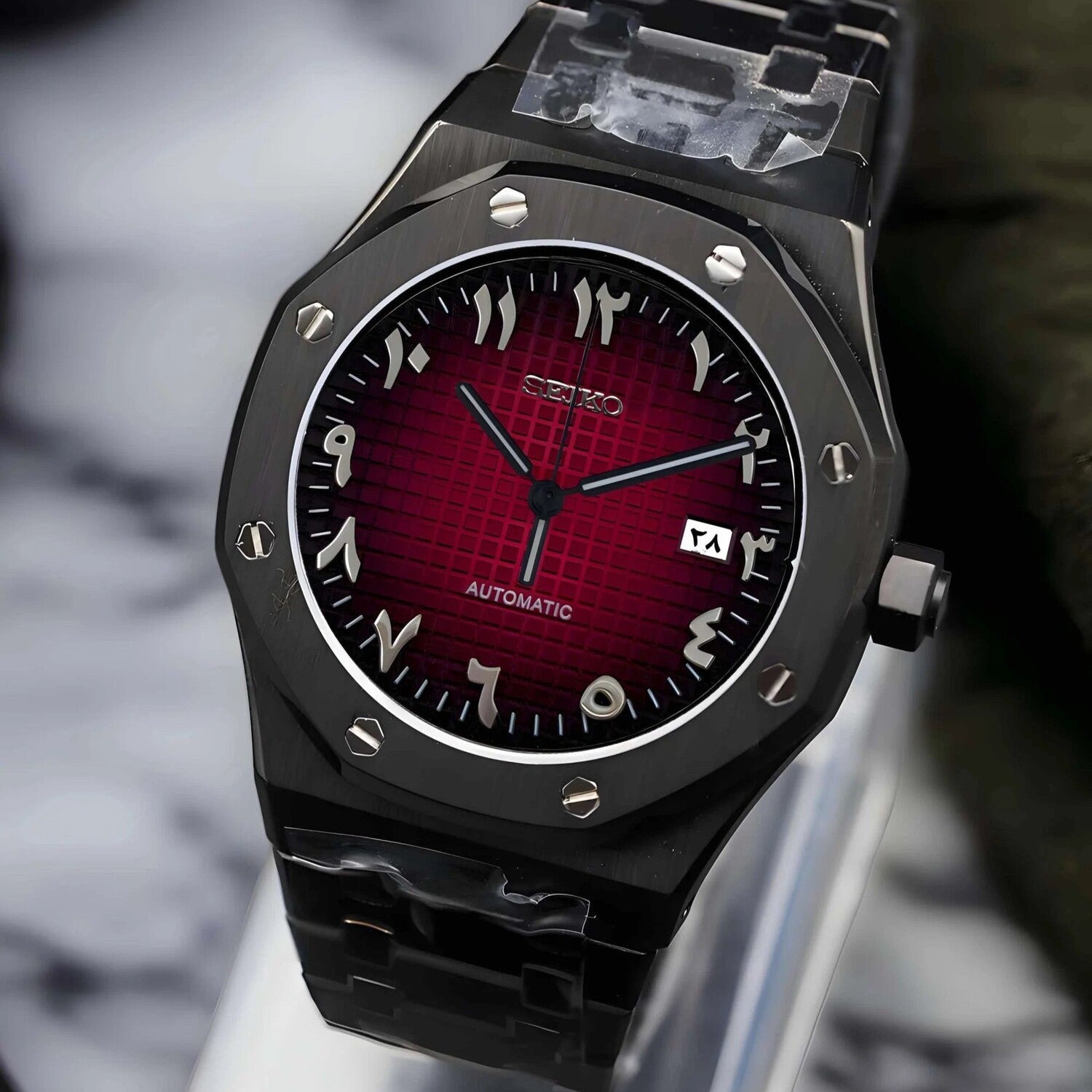 Seitenansicht der Seiko Mod Royal Oak Black Red Arabic mit auffälligem rotem Grid-Zifferblatt, silbernen arabischen Ziffern, gebürstetem schwarzem Edelstahlgehäuse und Automatikwerk