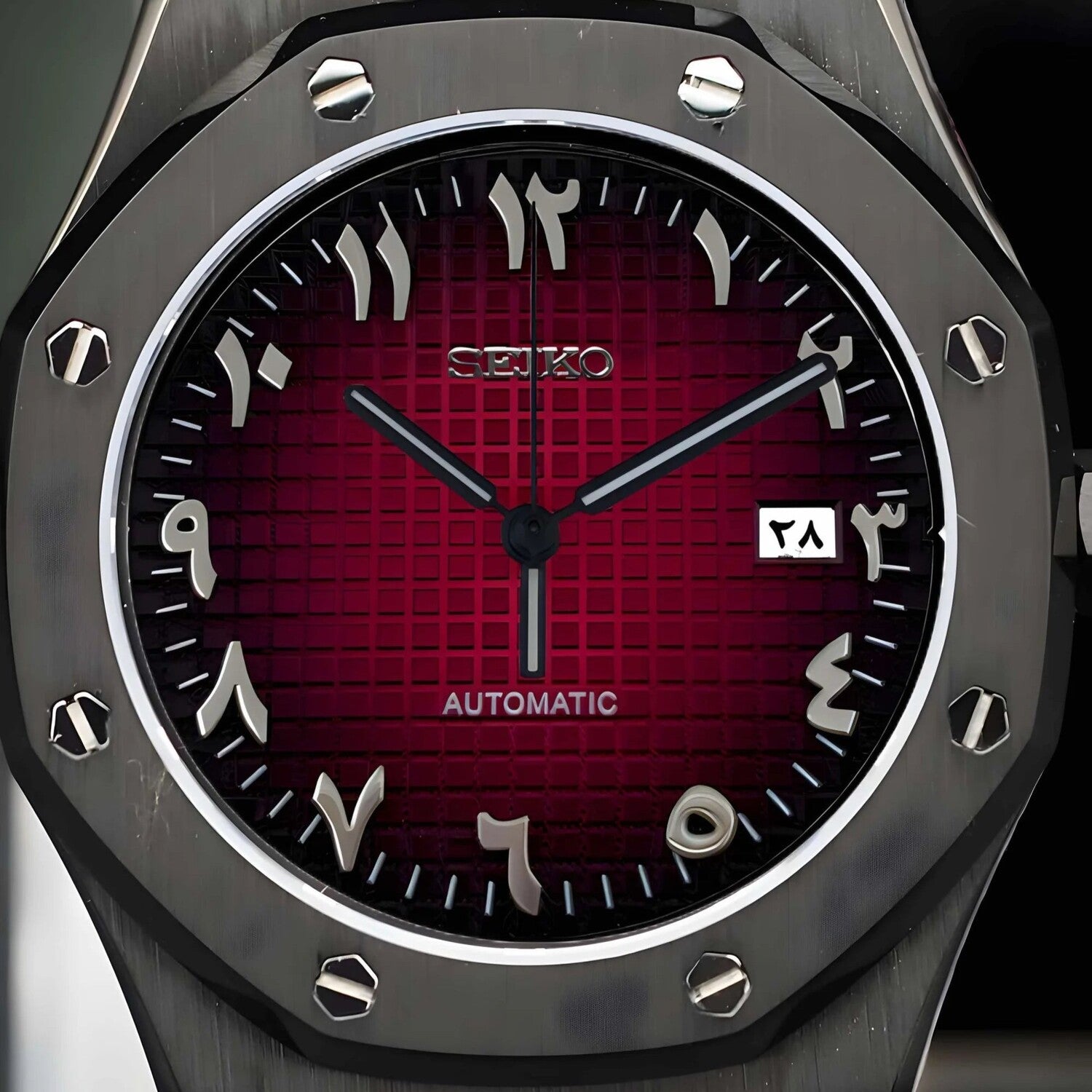 Nahaufnahme des Seiko Mod Royal Oak Black Red Arabic Zifferblatts mit tiefrotem Grid-Muster, silbernen arabischen Ziffern und schwarzer achteckiger Lünette