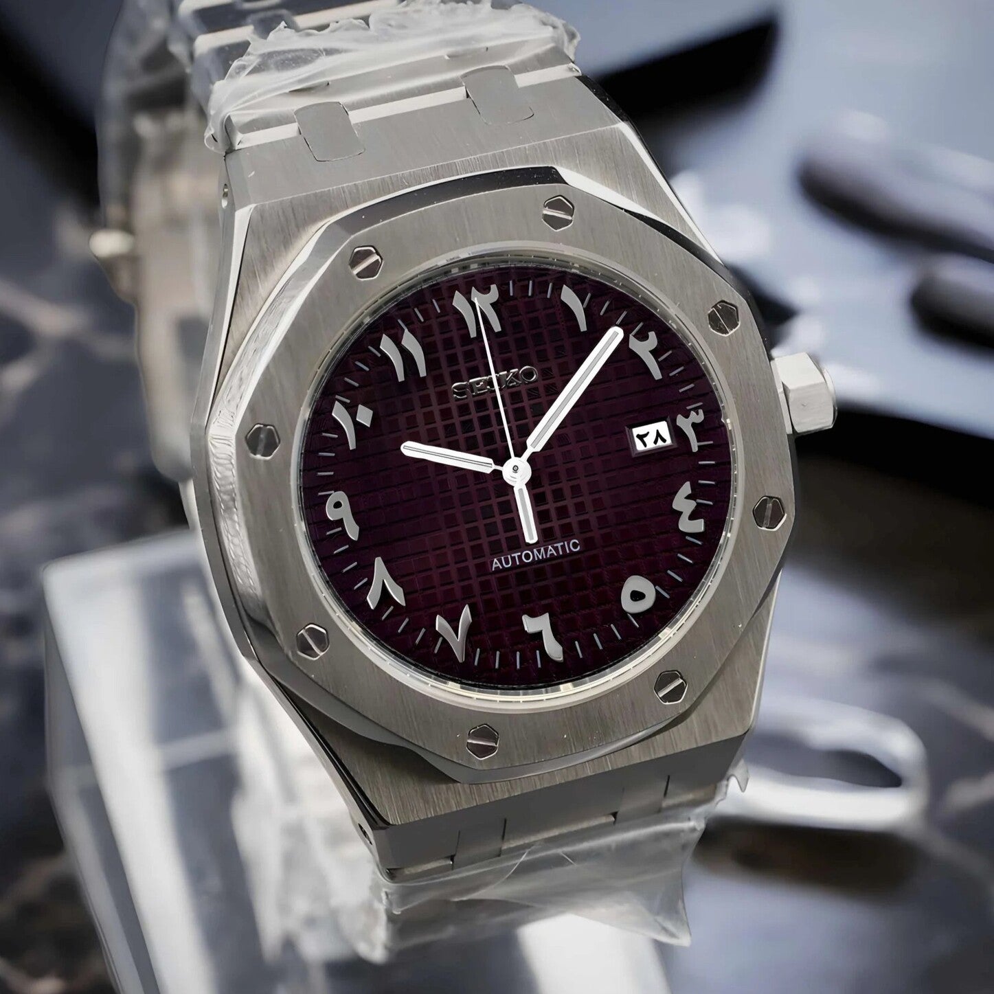 Linke Schrägansicht der Seiko Mod Royal Oak Brown Arabic mit gebürstetem Edelstahlgehäuse, tiefbraunem Zifferblatt und silber gerahmtem Datumsfenster