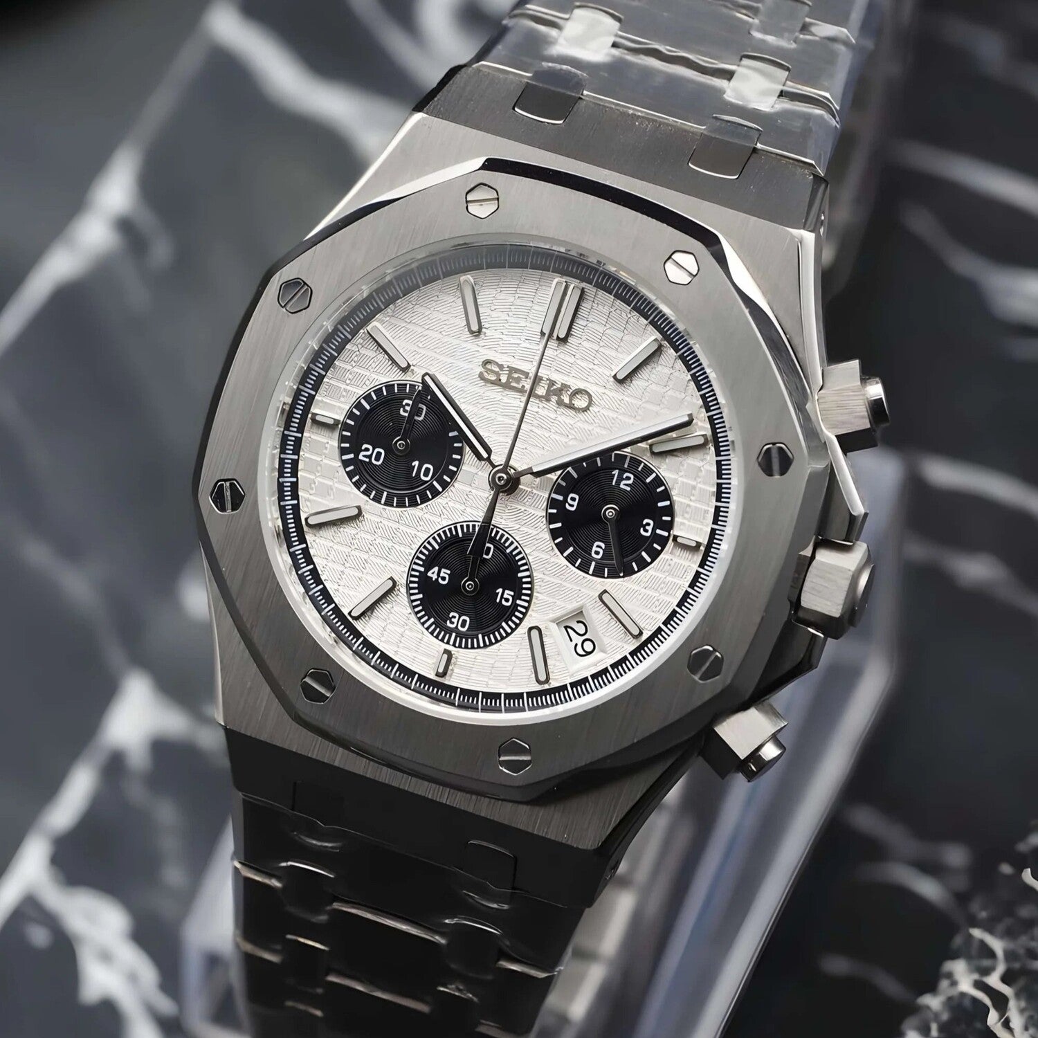 Seitenansicht der Seiko Mod Royal Oak Chrono Panda mit gebürstetem Edelstahlgehäuse, polierten Chronograph-Drückern und integriertem Armband