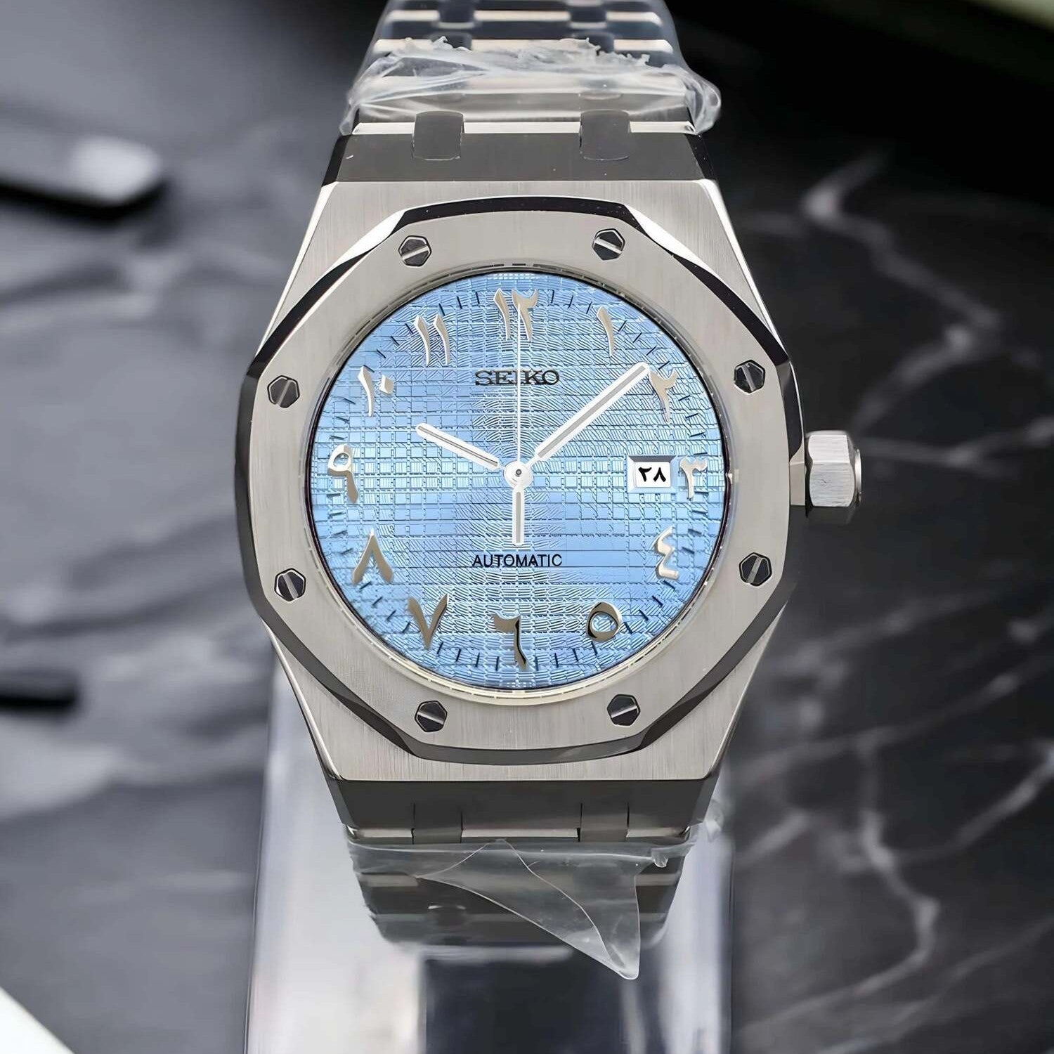 Frontansicht der Seiko Mod Royal Oak Ice Blue Arabic Luxusuhr mit eisblauem strukturiertem Zifferblatt, arabischen Ziffern und integriertem Armband