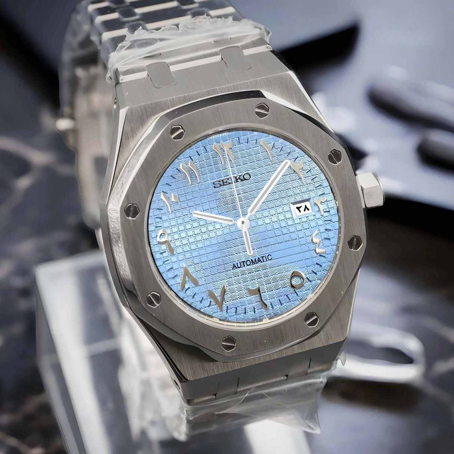 Linke Nahaufnahme der Seiko Mod Royal Oak Ice Blue Arabic mit eisblauem strukturiertem Zifferblatt, NH35 Automatikwerk und polierter Gehäusekante