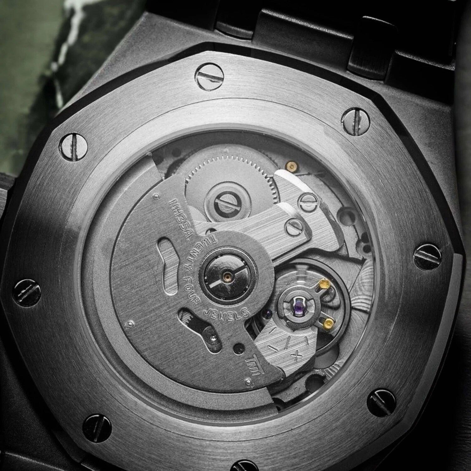 "Nahaufnahme des NH35 Automatikwerks der Seiko Mod Royal Oak White Arabic mit sichtbarem Rotor, Zahnrädern und polierten Schrauben