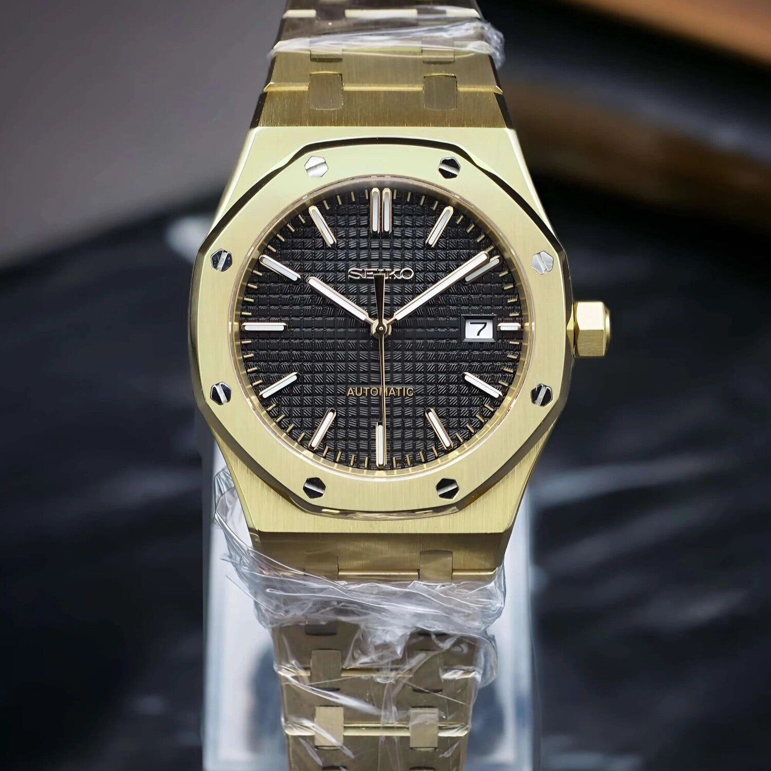 Frontansicht der Seiko Mod Royal Oak Yellow Gold Black Luxusuhr mit schwarzem Zifferblatt, leuchtenden Indizes und poliertem Goldgehäuse