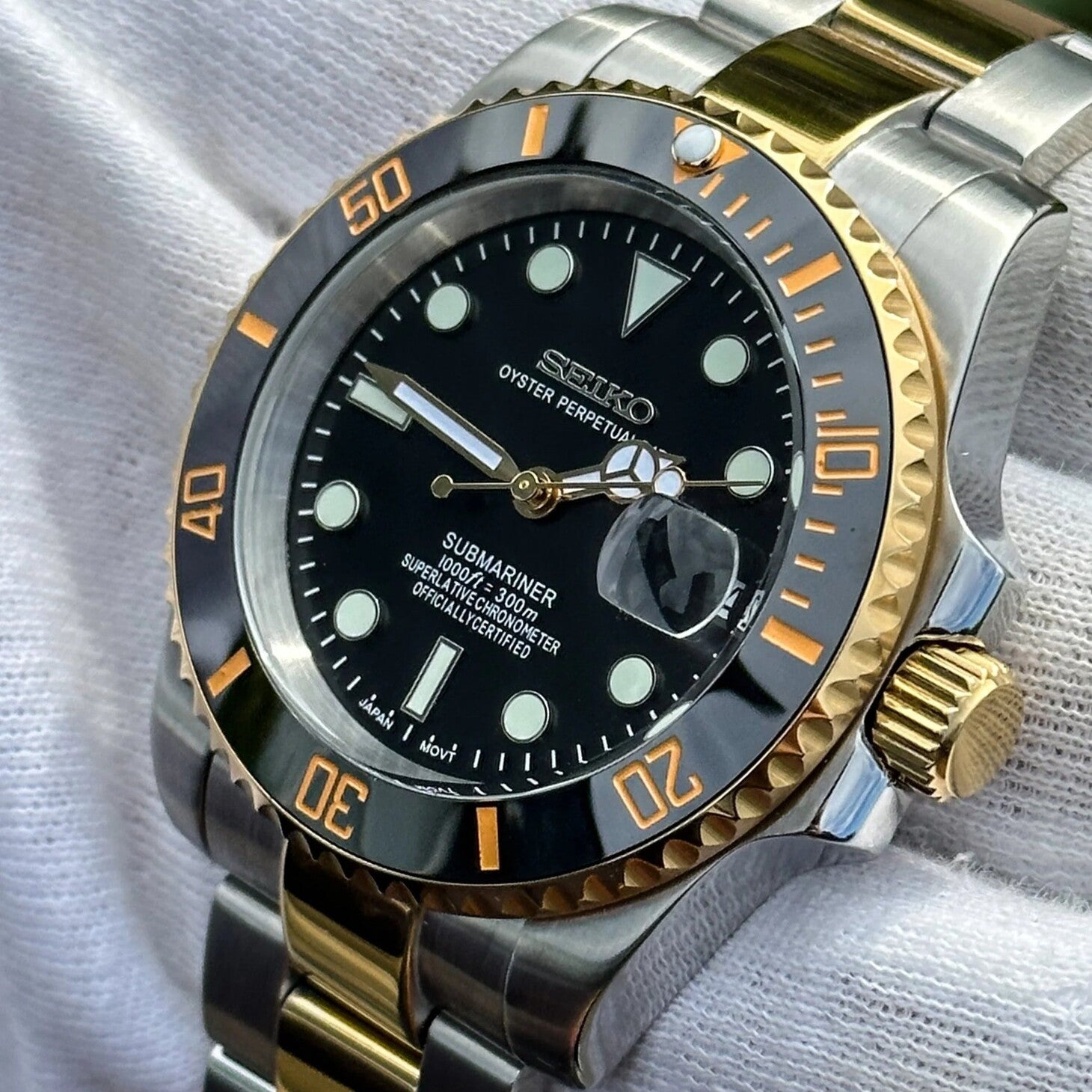 Seiko Mod Submariner Black Two-Tone Nahaufnahme mit NH35 Automatikwerk, goldener Krone und Keramik-Lünetten-Detail